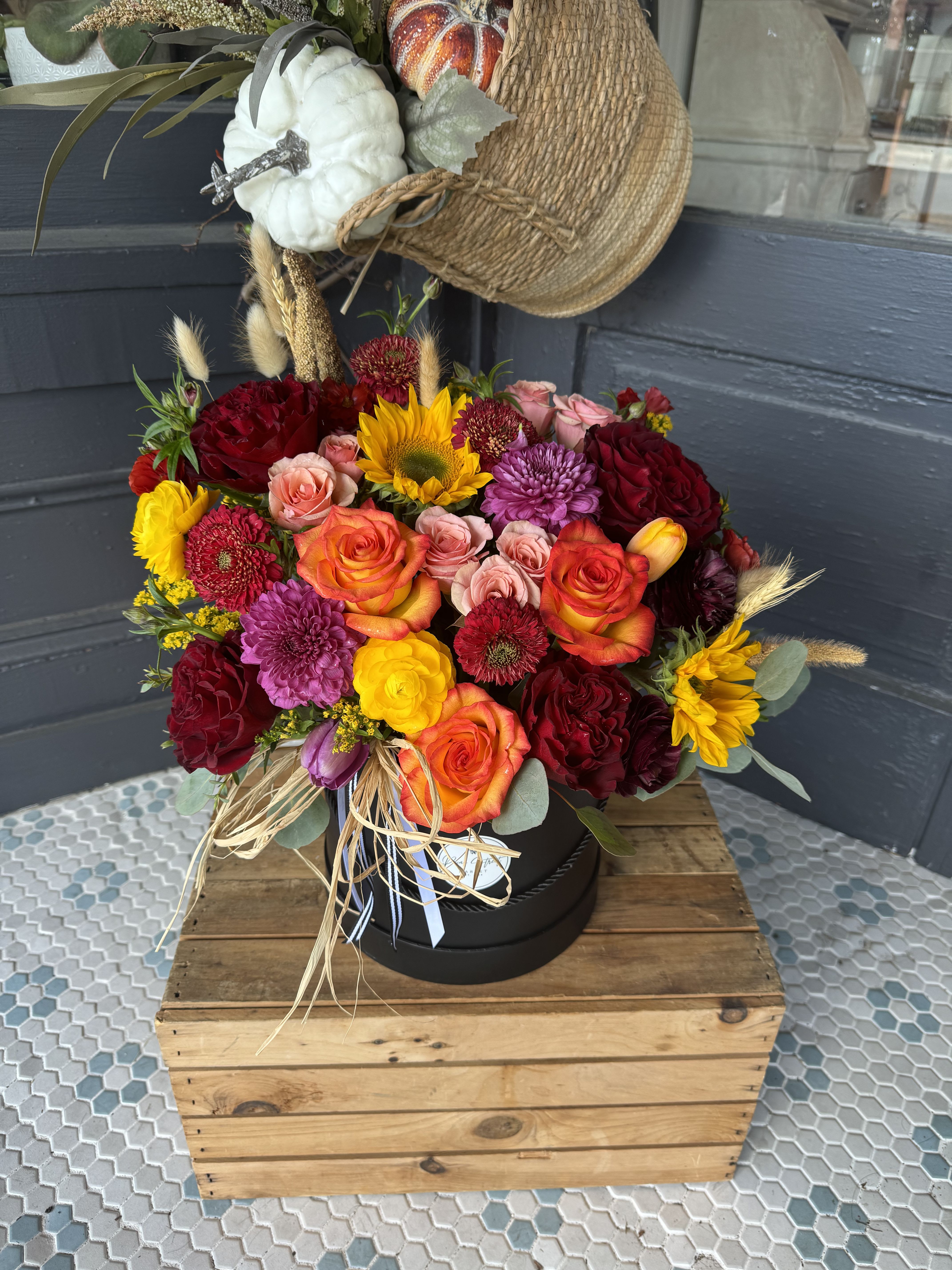 Autumn Harvest - A beautiful mix of fall colors with roses, ranunculus, sunflowers, and dried grasses that come together to make a stunning statement. 