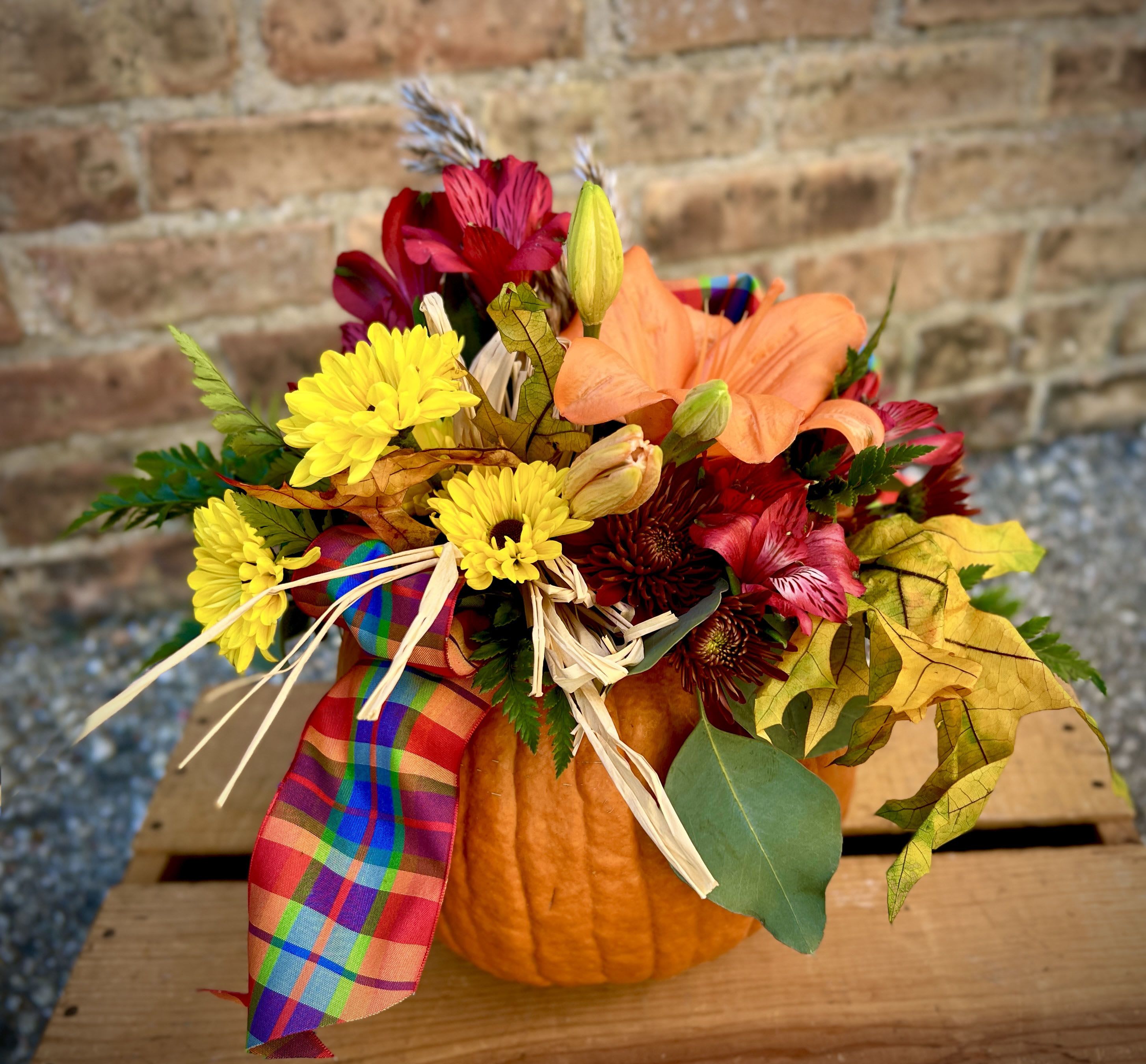 Shades of Fall - Fall is here with all the beautiful colors that it brings. Fall lilies, mums, and alstromeria highlight the season. Arranged in a fresh pumpkin with fall ribbon, leaves, and accents. Truly unique and always appreciated for any occasion.  We are proud to deliver our flower creations to the Kenosha, Somers, and Pleasant Prairie areas. With over 55 years of combined flower design experience in Kenosha, Wisconsin, A Summer's Garden Florist and Gifts is the perfect choice for the freshest flowers, most creative design, and exceptional customer service.
