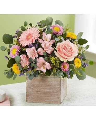 SPRING SENTIMENT - Spring is a time to refresh and reach out. Our new spring bouquet celebrates that sentiment. Soft pink and yellow blooms are loosely gathered with lush greenery for style and texture. Designed in our rustic, grey-washed wooden cube, it’s a gift that delivers on your feelings in the most beautiful way. 