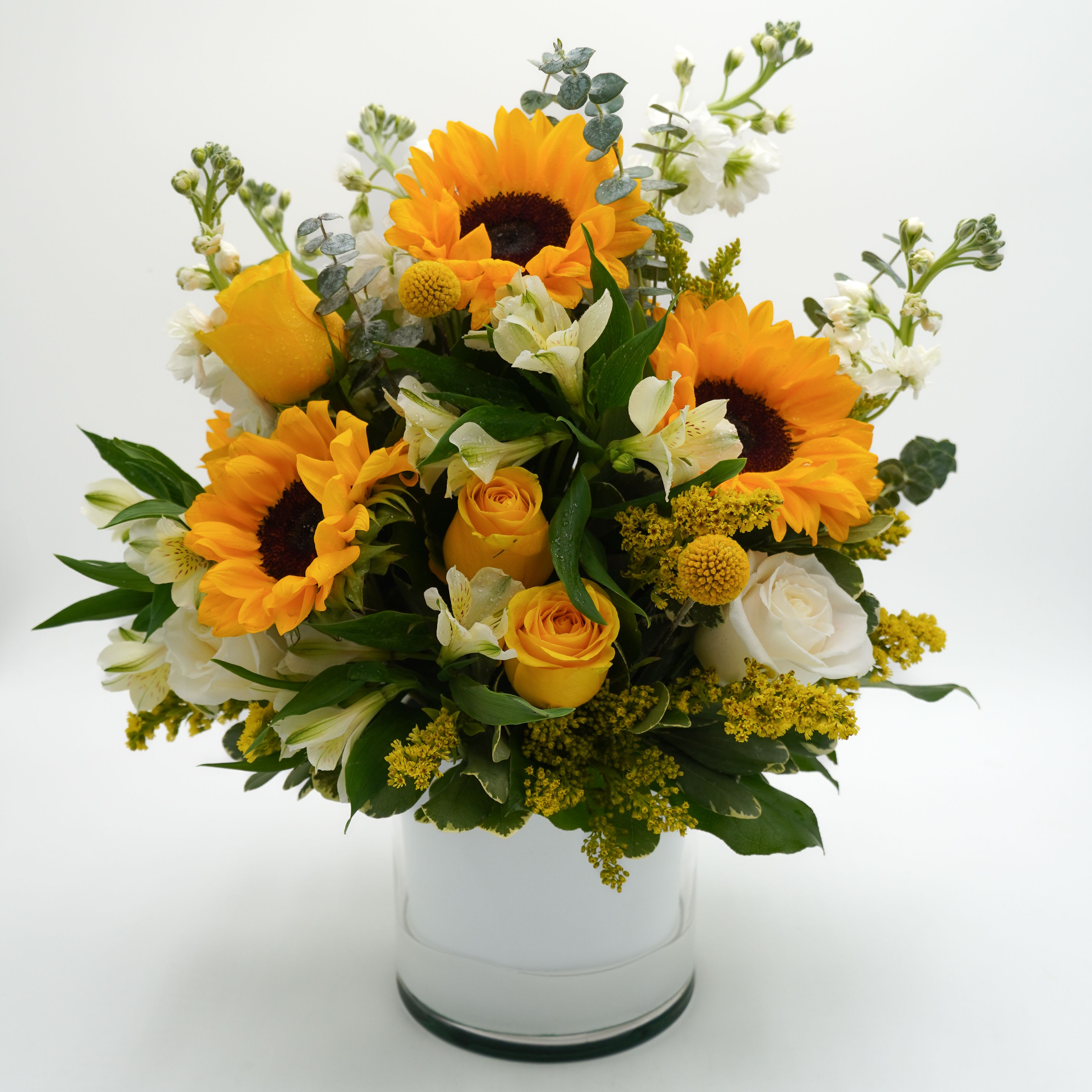 Warm Sunflowers Warm Sunflowers - Includes sunflowers, white stock, yellow aster, alstroemeria, and yellow/white roses.  Vase Size: 6x6