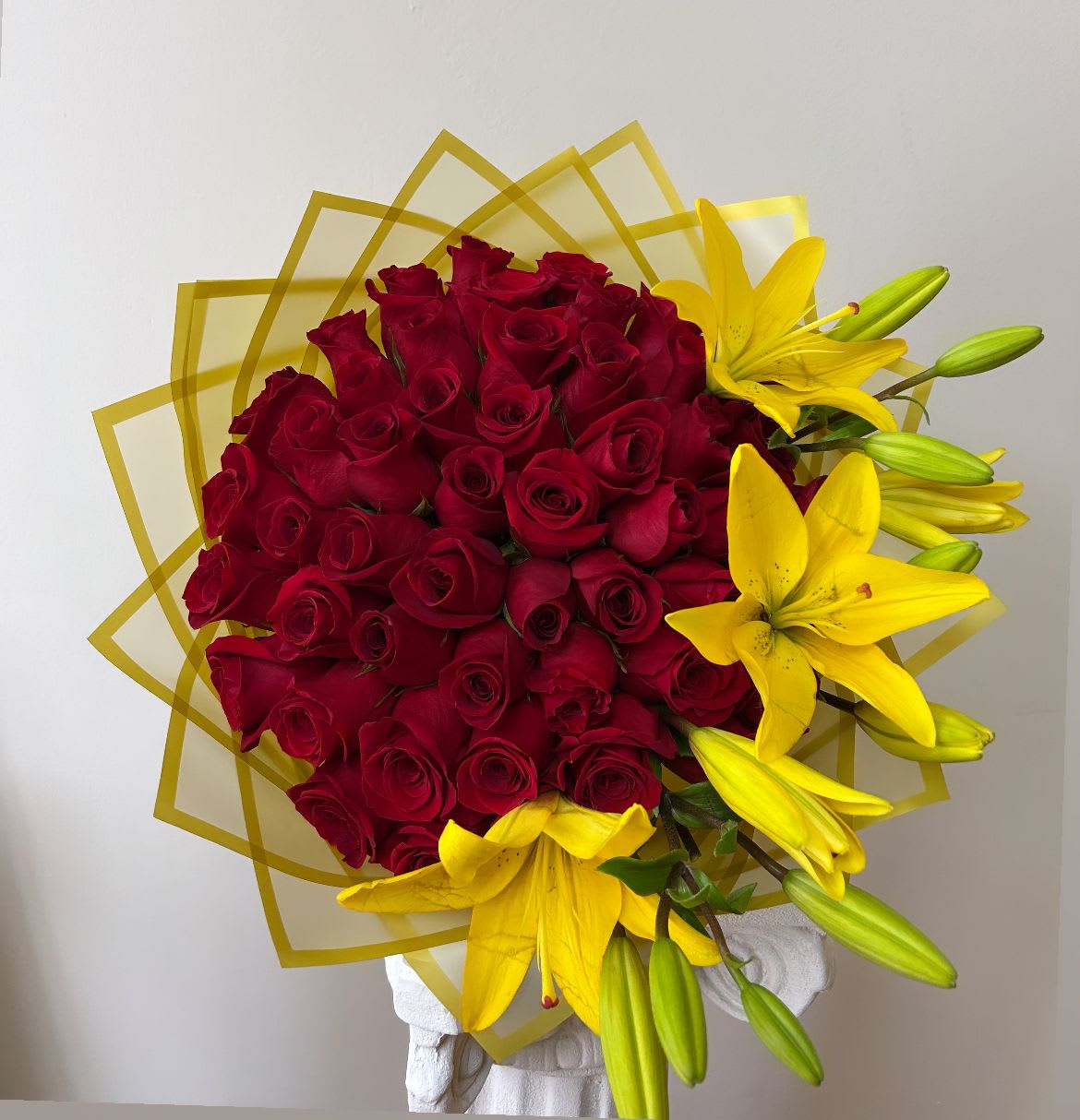 Passion and Joy Bouquet  Passion and Joy Bouquet -  Passion and Joy Bouquet   A majestic arrangement composed of 50 red roses, a symbol of intense love and passion, combined with yellow lilies that bring light, joy and positive energy.  Each flower is carefully selected to create a perfect balance between romanticism and vitality, resulting in a shocking, elegant bouquet full of life.