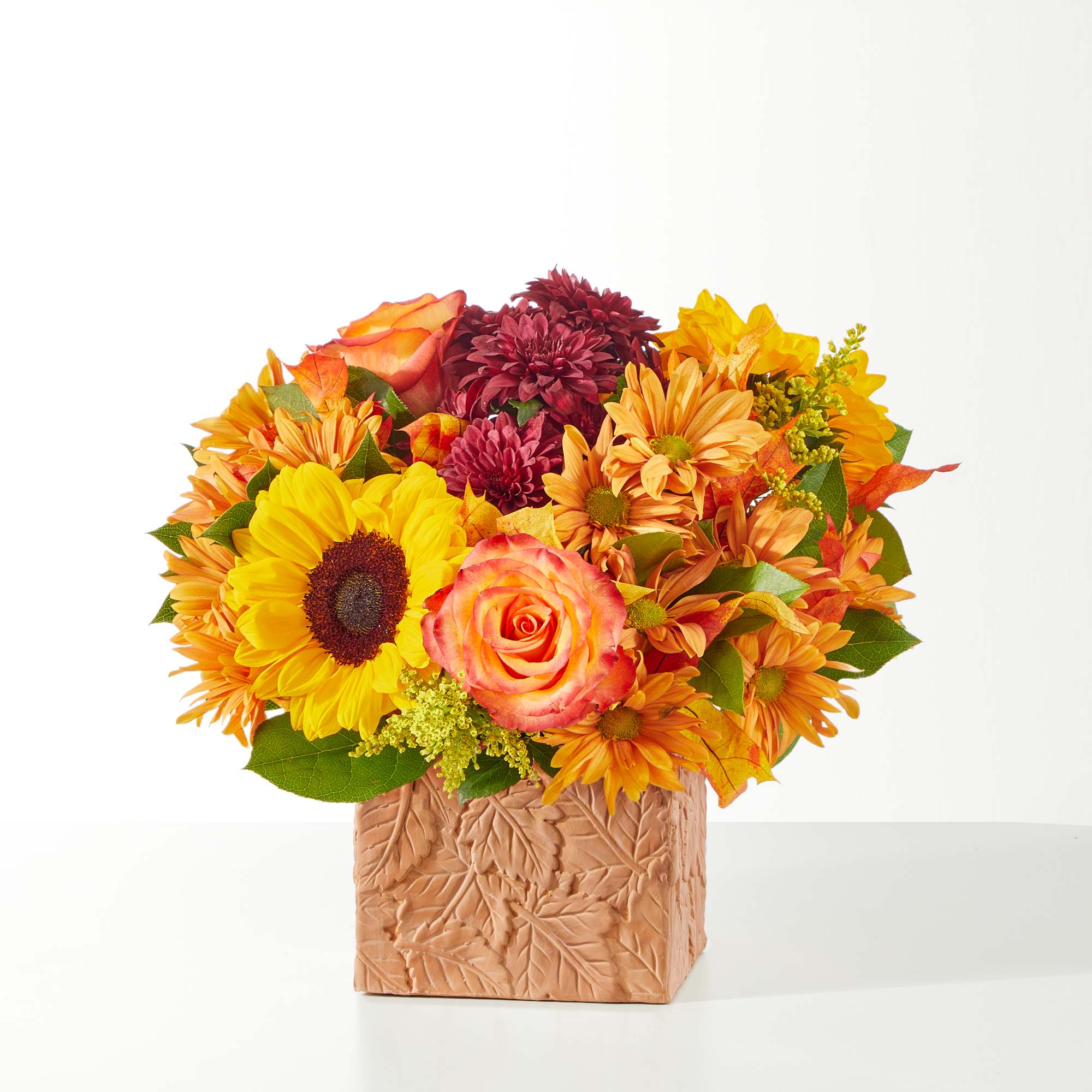 F10 - OUTDOORS BOUQUET OR SIMILAR - Terra cotta leaf cube packed with fall colored sunflowers, roses, daisies, etc.