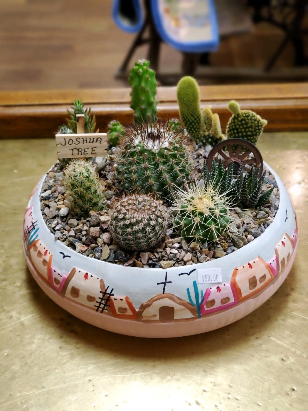 Large Adobe Style Cactus Garden  Large Adobe Style Cactus Garden  - A variety of 8-9 different types of cacti in a beautiful hand-painted pot with rocks, cactus sign and wagon wheel.