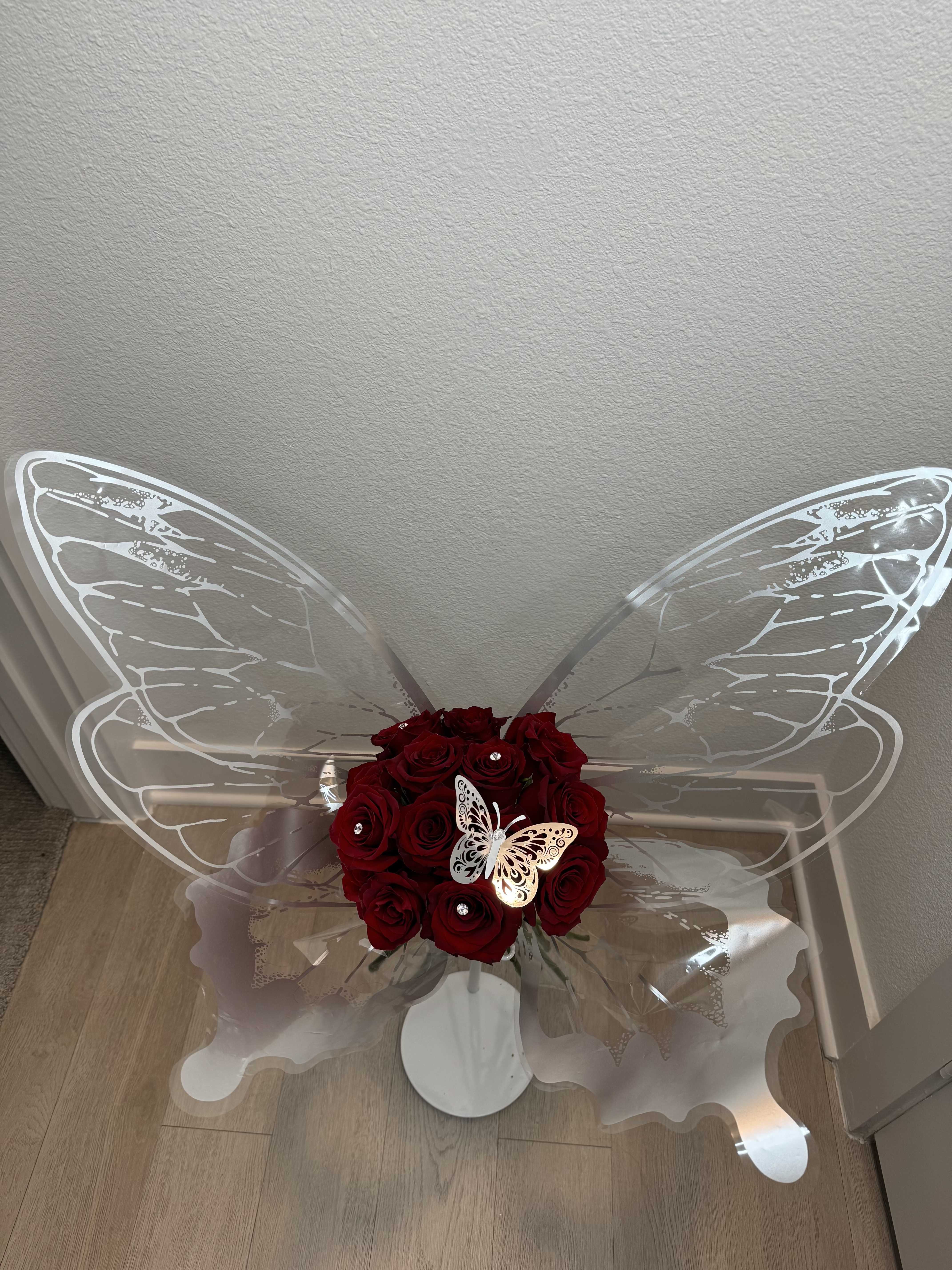 Silver Butterfly - A graceful arrangement of rich red roses adorned with a shimmering silver butterfly wrapped delicately around the bouquet, with another sparkling butterfly nestled at its heart. Elegant and enchanting, this design is a symbol of beauty, transformation, and everlasting love.