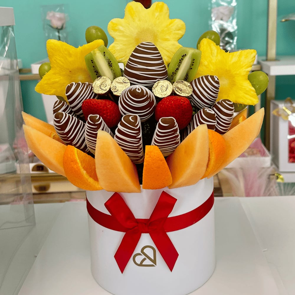 fruit Bouquet Big Deluxe -  Large Fruit Bouquet with Chocolate Strawberries &amp; Chocolate-Covered Slice – Perfect for Birthdays, Get Well &amp; Friends Bright, cheerful, and absolutely delicious! This large fruit arrangement is a show-stopping gift filled with chocolate-covered strawberries, juicy fruits, a premium chocolate slice, and a touch of gold. Whether it’s for a birthday, a get-well wish, or just to show someone you care, this bouquet makes the moment unforgettable.  Includes:   Chocolate-dipped strawberries with white swirl design  Star-shaped pineapple slices, Chocolate covered Apple  One chocolate-covered fruit slice (for an extra treat!)  Fresh strawberries, kiwi slices, green grapes  Orange wedges and cantaloupe pieces  Gold-wrapped chocolates for a sweet luxury touch  Arranged in a modern white hat box with red ribbon  Delivered in a clear acrylic gift box for elegant presentation  Perfect for:   Birthday gifts  Get well soon surprises ‍️ Sweet gifts for friends  Freshly made in Miami Springs | Local delivery available  