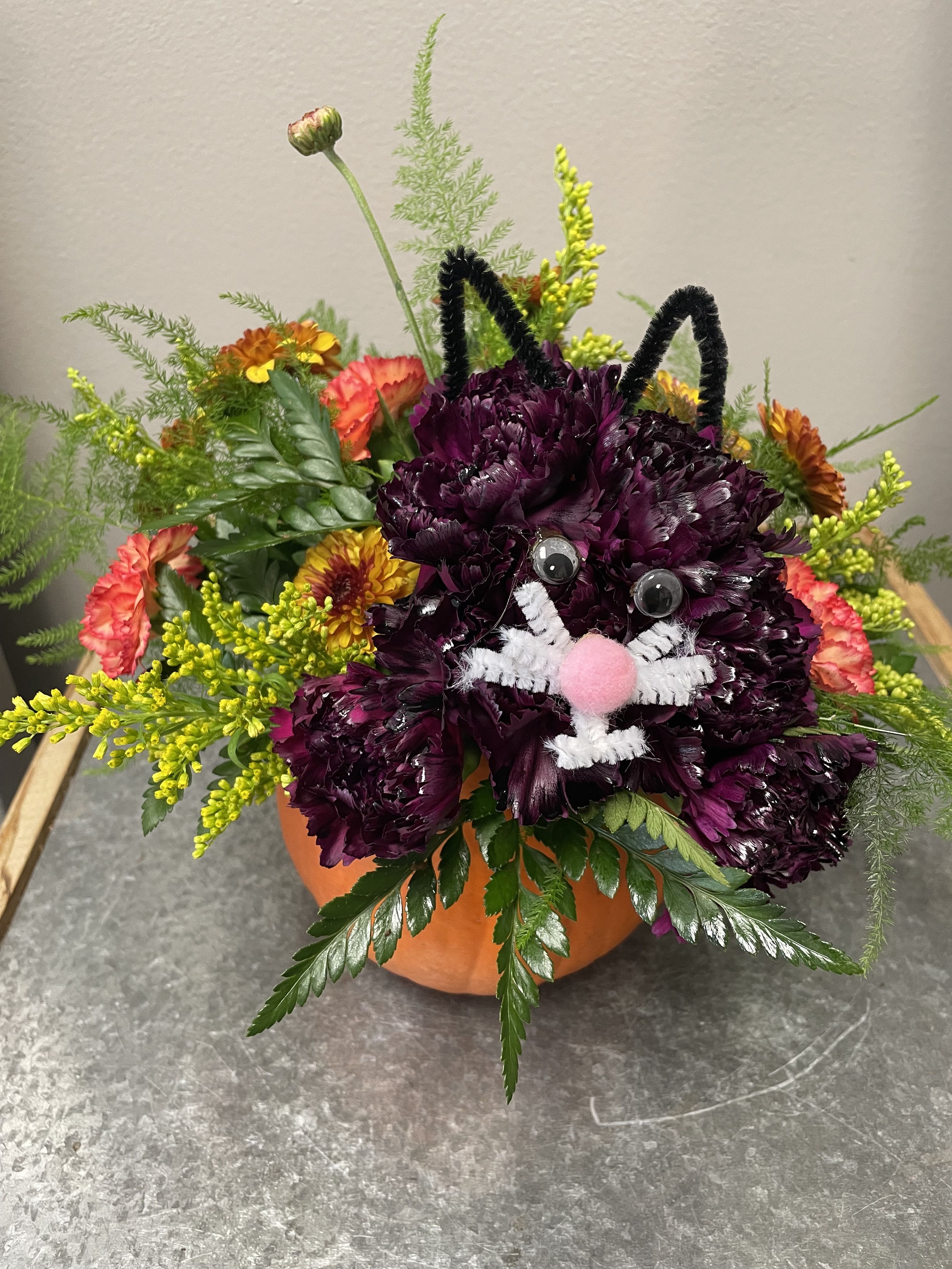 Pumpkin with Halloween Cat Pumpkin with Halloween Cat - Nothing is cuter than a fresh bouquet for Halloween than a bouquet with a flower cat! This pumpkin is filled with seasonal and festive flowers and adorned with a cute flower cat. Perfect gift to send for Halloween or to pick up for a fun and festive centerpiece for your gatherings!