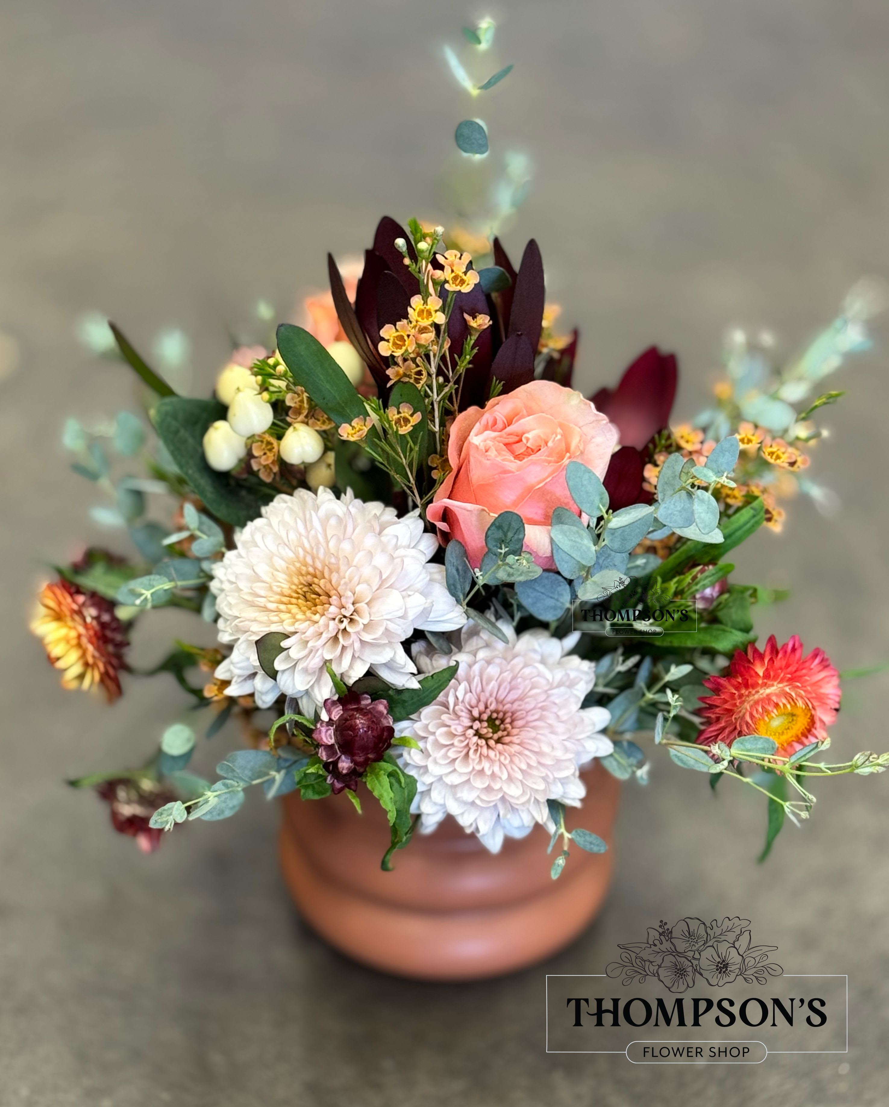 Copper Canyon Blooms Copper Canyon Blooms - Handcrafted by Thompson’s Flower Shop in Goodyear, Copper Canyon Blooms blends soft peach roses, lush mums, burgundy blossoms, and eucalyptus with autumn textures. Designed in a rustic terracotta vase, this seasonal favorite is available for same-day delivery in Goodyear, Avondale, Buckeye, Litchfield Park, Peoria, and Vistancia. A perfect way to send fall flowers across the West Valley with local care and style.