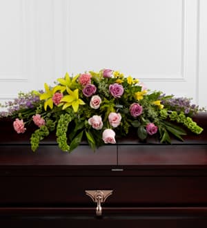 The Forever Beloved Casket Spray The Forever Beloved Casket Spray - The Forever Beloved Casket Spray beautifully illuminates the atmosphere of their final farewell service. Lavender roses, pink roses, lavender larkspur, pink carnations, Bells of Ireland, yellow Asiatic lilies, yellow freesia, solidago, and lush greens are arranged to create an extravagant display of floral beauty that offers comfort and peace to the friends and family of the deceased.