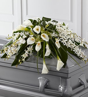 The Angel Wings Casket Spray The Angel Wings Casket Spray - The Angel Wings Casket Spray is an exceptionally gorgeous way to bring peace and beauty to their final farewell service. White Dendrobium orchids, white calla lilies, green hydrangea and a variety of lush greens are artfully arranged to perfectly adorn the top of their casket, offering the colors and ambiance of grace and serenity.