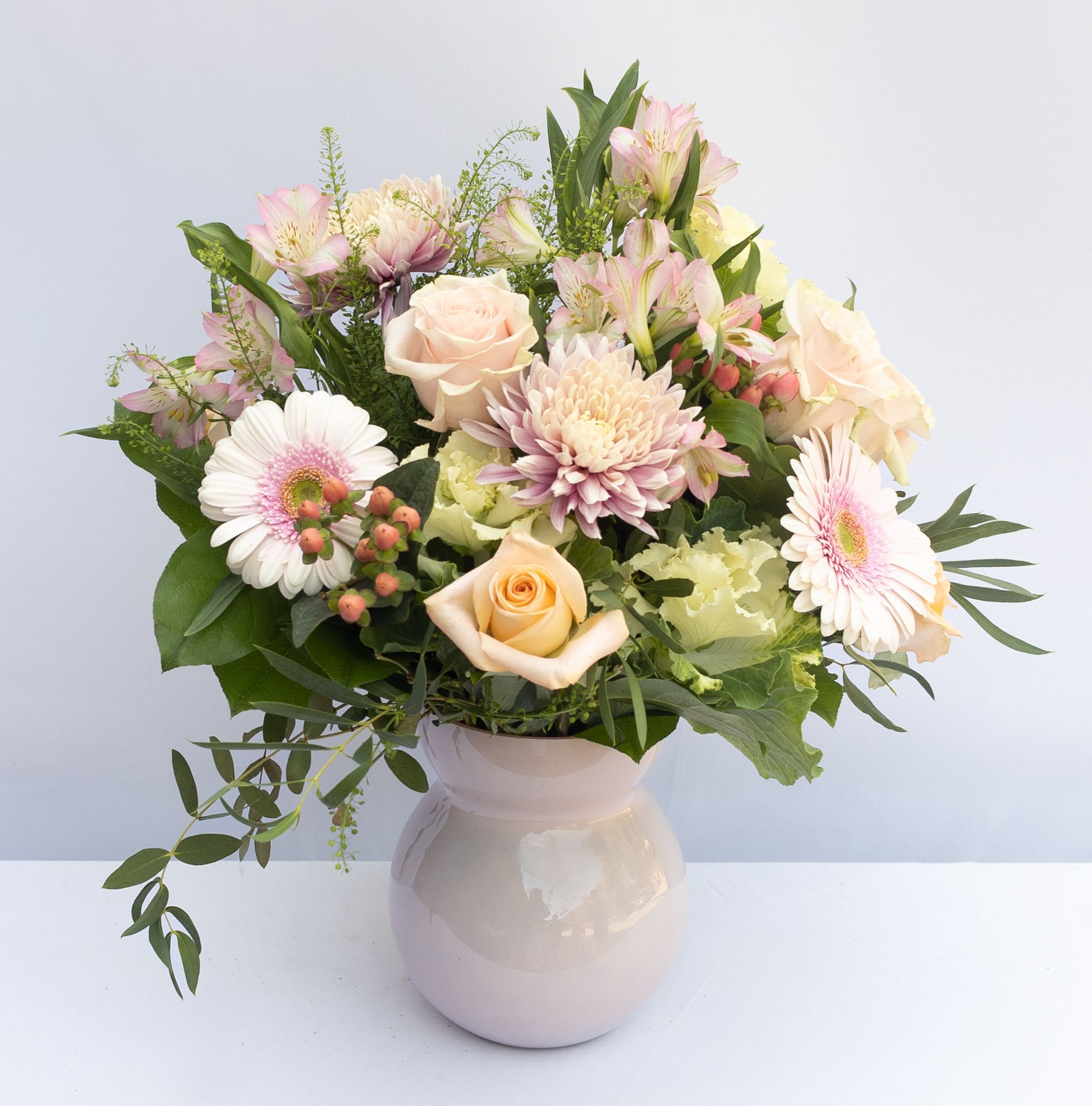 Pink Lady  Pink Lady  - A chic matte soft pink Accent Décor vase with  a dozen assorted pastel roses in pinks, lavenders, & whites accented with spray roses, fillers, alstroemeria, and assorted greenery.  Vase is 8hx5w. Arrangement is about 20hx17w designed.