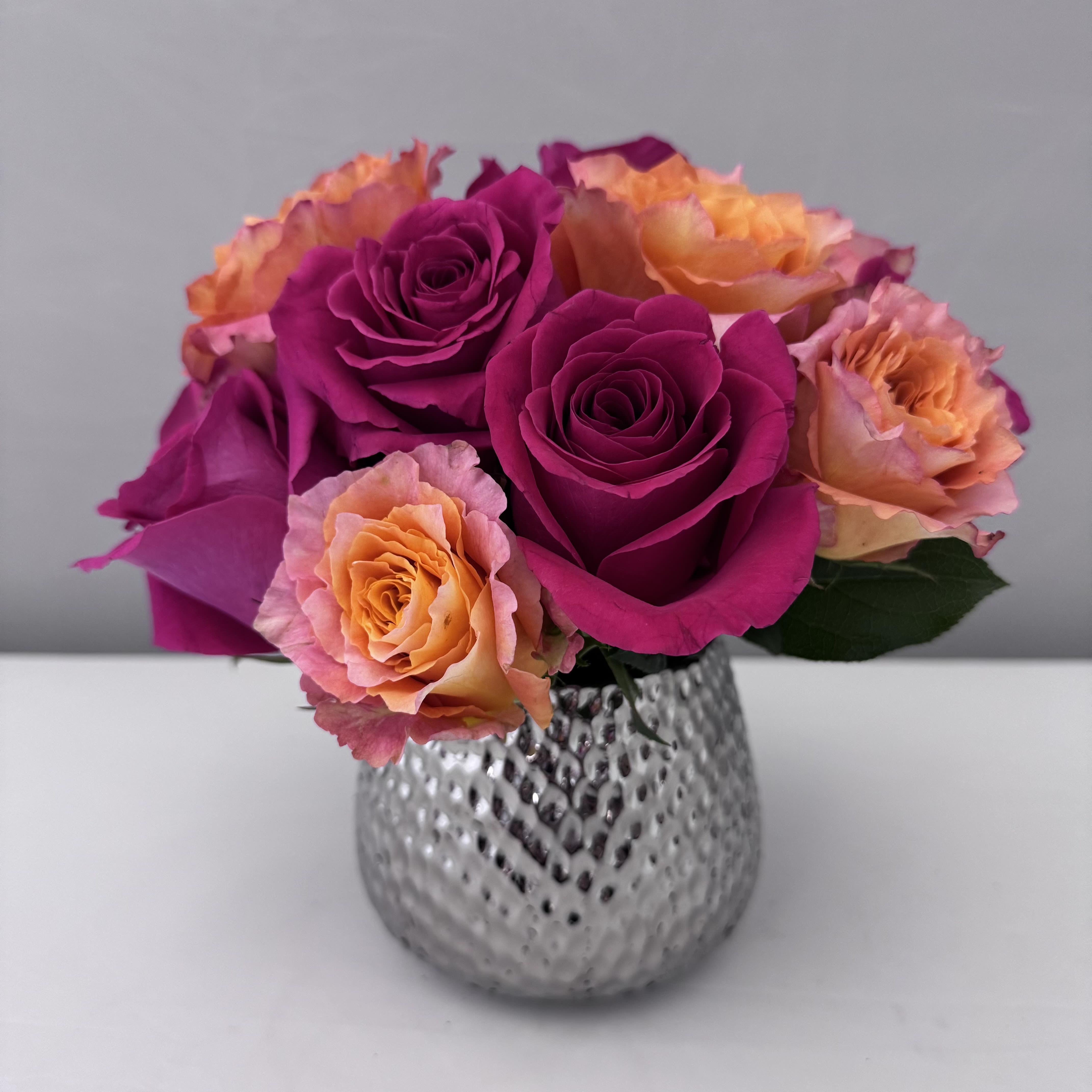 CRUSH  - A VIBRANT MIX OF HOT PINK FLOYD AND ORANGE FREE SPIRIT ROSES IN A PETITE TEXTURED SILVER POT.  CONTAINER IS 5WX4.5H. 