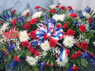 Casket Spray - Patriotic Casket Spray - Patriotic - This is our patriot memorial for the man or woman who has served our country. The red carnations, blue iris, white fuji mums, and babies breath are a perfect tribute.