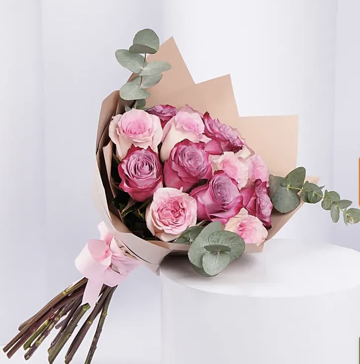 Blush Harmony  - Soft. Sweet. Stunning. – Blush Harmony for Mother’s Day  Let Mom know just how much she means with Blush Harmony — a luxurious bouquet of soft pink and lavender-toned roses wrapped in elegant kraft paper and tied with a delicate satin bow. This bouquet speaks the language of love, admiration, and grace with every bloom.  The gentle blush tones and fresh eucalyptus accents create a peaceful, elegant arrangement that’s as timeless as a mother’s love.  What’s Inside: 	•	Hand-selected blush, pink, and lilac roses (love, gratitude &amp; elegance) 	•	Fresh eucalyptus sprigs for a modern, aromatic touch 	•	Wrapped in matte kraft paper with pink ribbon detailing  Perfect For: 	•	A heartfelt Mother’s Day surprise 	•	A beautiful reminder of your affection 	•	Elegant home décor
