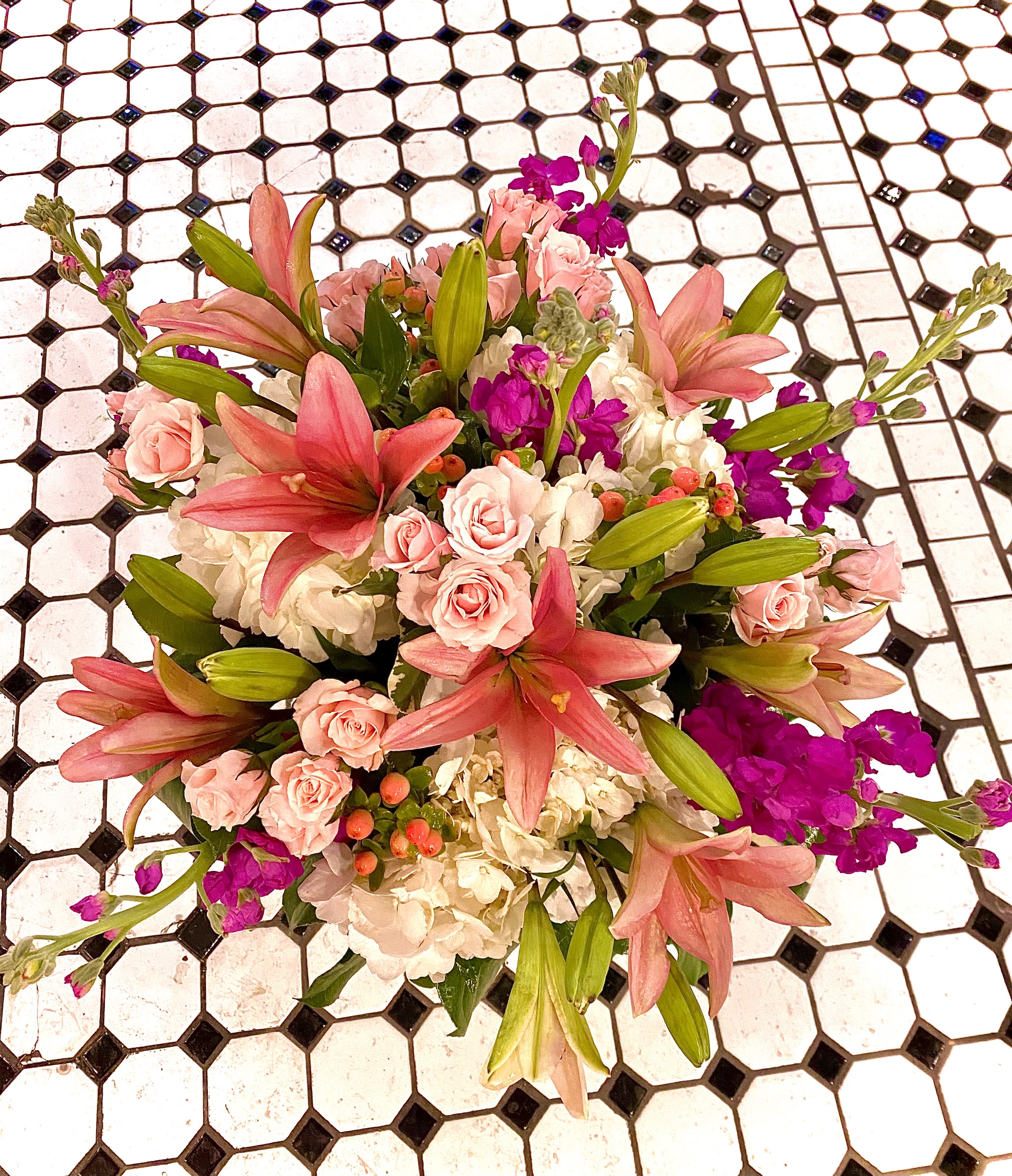 Pretty in Pink - So pretty, this lush little arrangement, presented in a clear glass vase, will bring beauty overflowing with Roses,  Hydrangea, and an array of locally grown pink flora.
