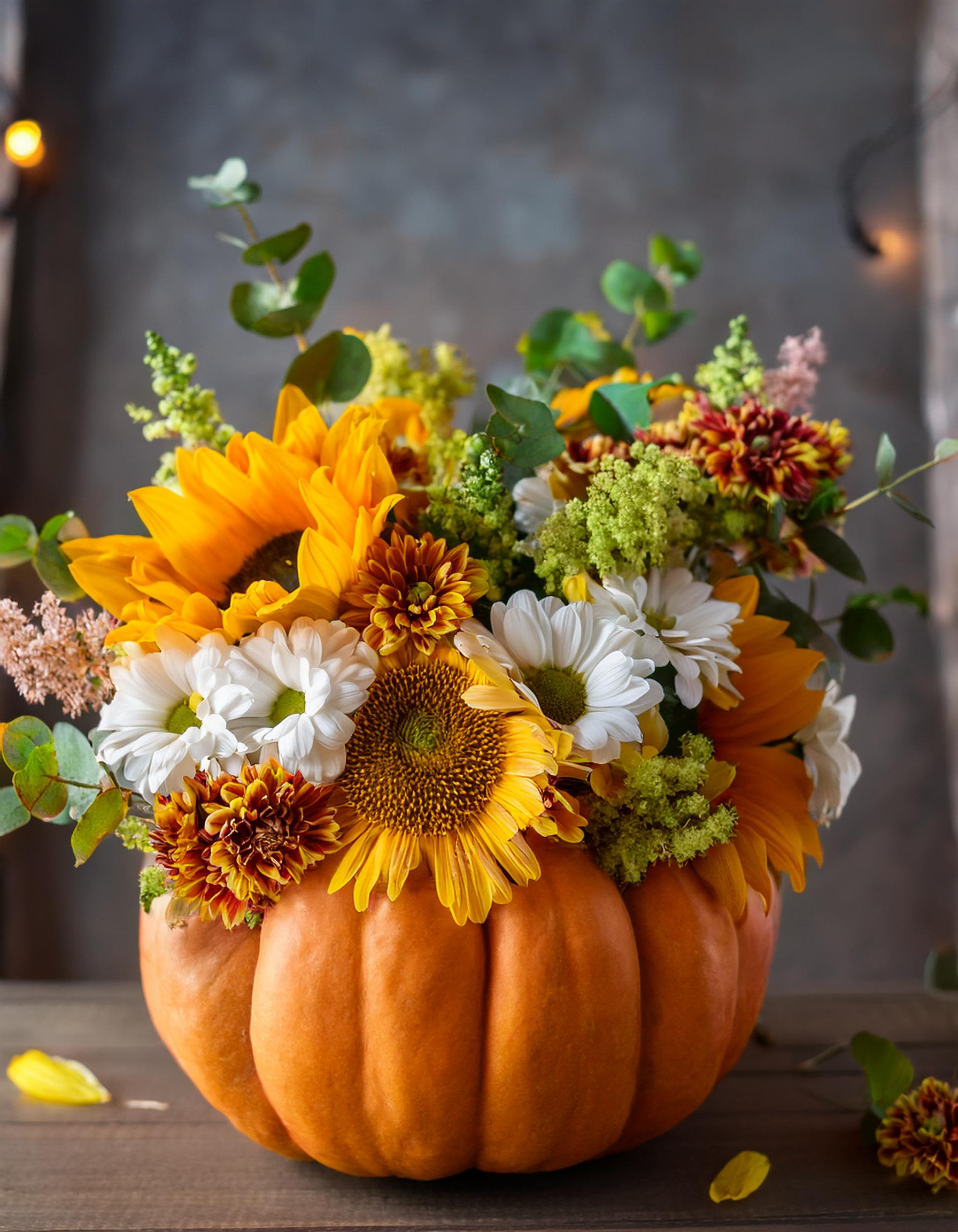 Pumpkin Blossom Symphony - This exquisite floral arrangement showcases rich, warm hues and delicate flowers arranged in a beautifully carved pumpkin, creating a delightful centerpiece for any autumn occasion.