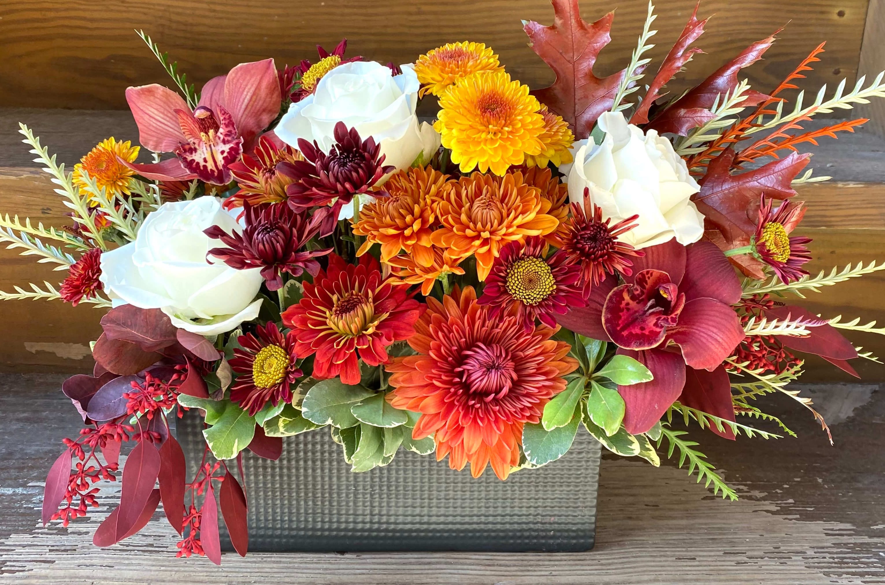 Foot Long Modern Fall Centerpiece w/ Orchids - Colors may vary - Fall florals, orchids and greens in a modern design in a low vase or box (container may vary depending on availability) 