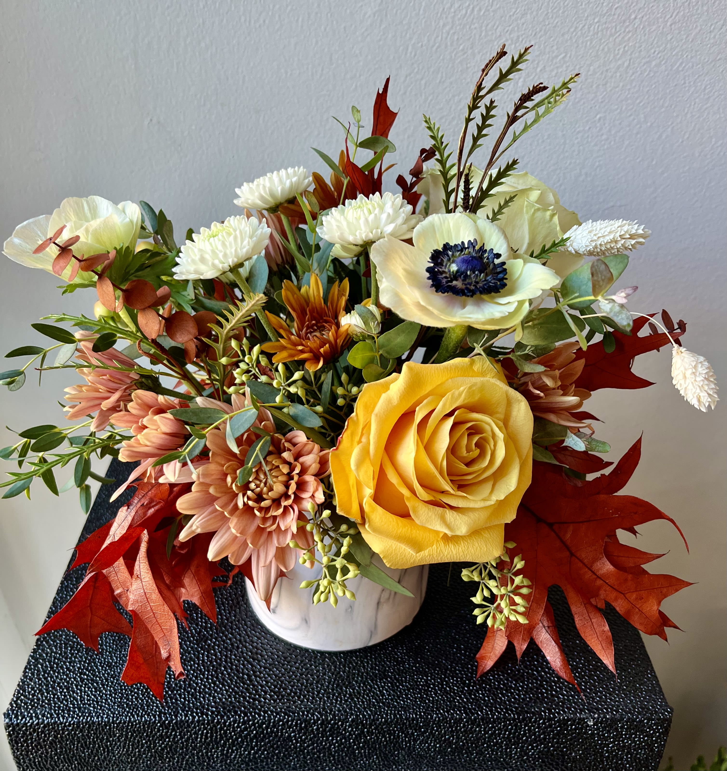 Autumn Harmony  - SMALL Low Premium Arrangement in 4” white ceramic marble cylinder with muted fall tone roses, mums, eucalyptus and white anemones.    