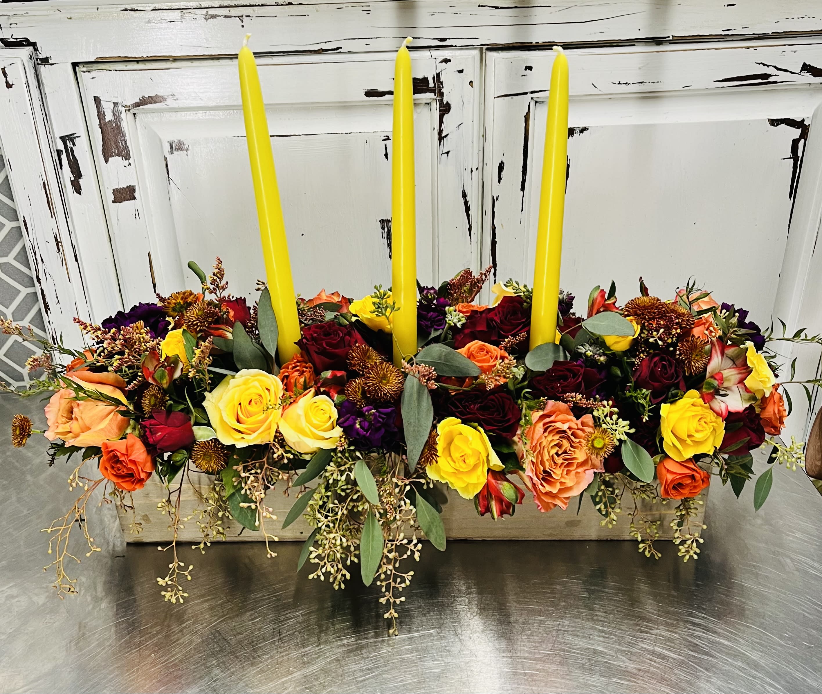 Fall Harvest Centerpice Fall Harvest Centerpice - No dinner party or fall harvest gathering is complete without a festive, holiday centerpiece and this beautiful arrangement makes a big statement on any holiday table. Featuring (3) taper dinner candles and a variety of fall flowers, dress up any event with this arrangement. Send it as a wish I could be there with you gift or a just because I love you gift. Any reason is good to receive this beauty.