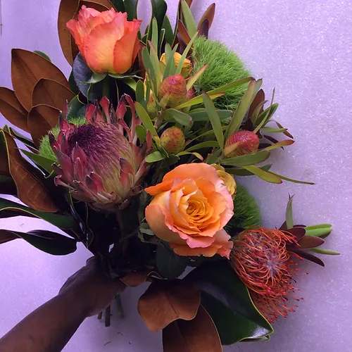 Warmer Nights - It's like travelling the world with flowers: Magnolia; Proteas; Dianthus; Proteas and Rosesin deep earth tones all in one bouquet. How could that not have you feeling warm and cozy at night?     Medium $105 (w/vase $135)  Large $155 (w/vase $205)  X-Large $210 (w/vase $270)     Pictured here is our large bouquet.  Bouquet will be delivered approximately as pictured.