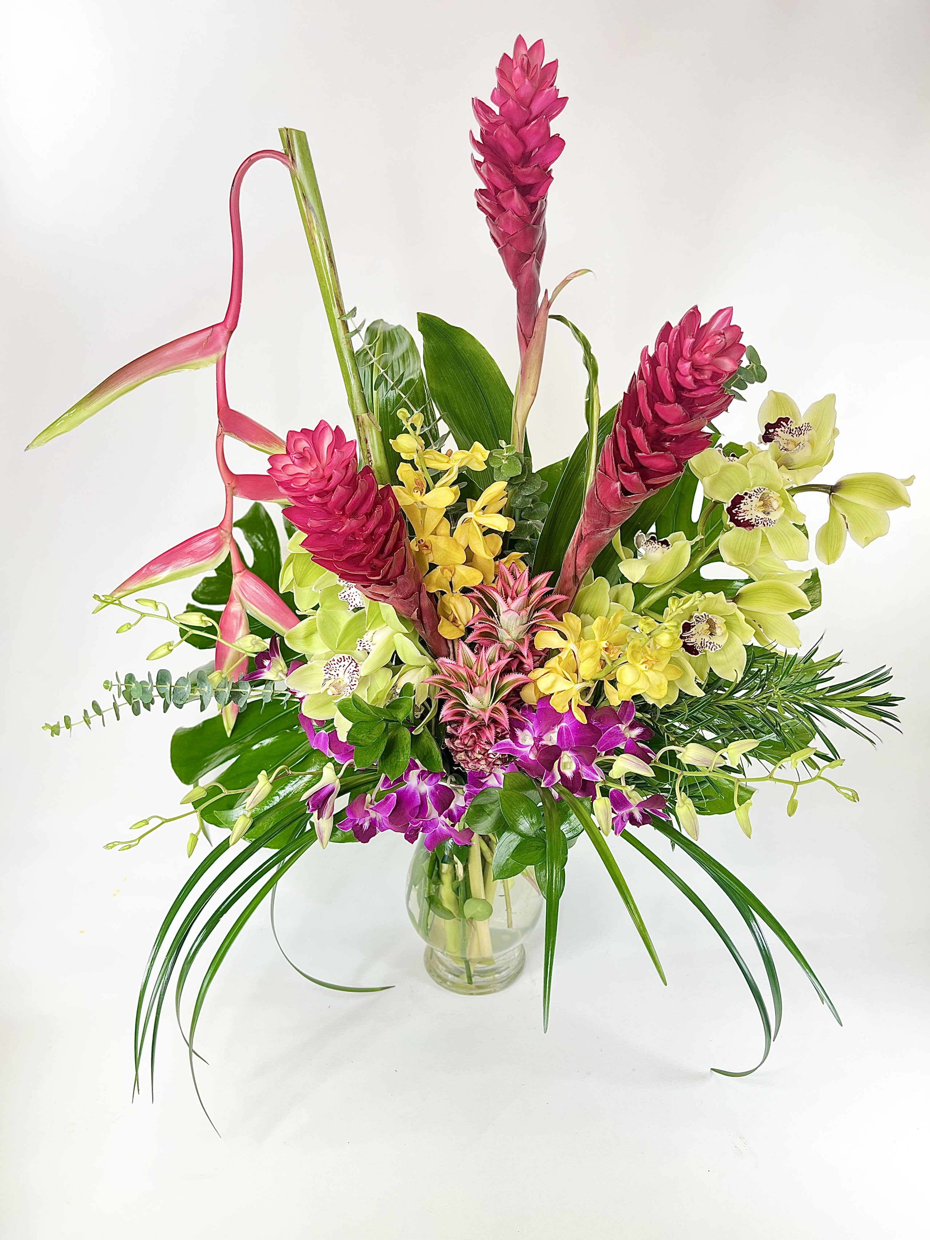 Orchids Galore Orchids Galore - This stunning tropical arrangement has cymbidium, oncidium, and dendrobium orchids with pineapple, red ginger and hanging heliconia.