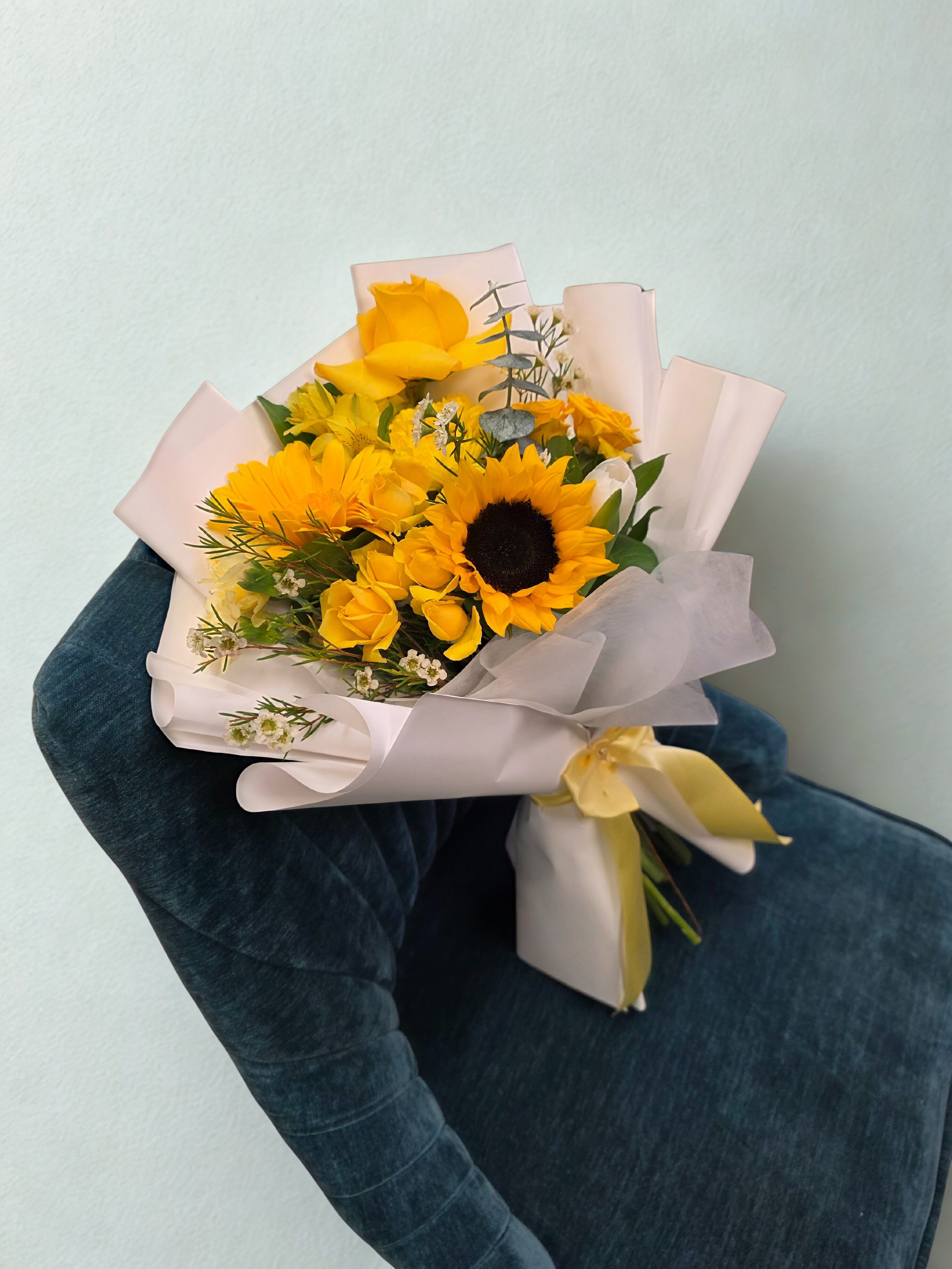 Sunshine Delight Bouquet Sunshine Delight Bouquet - Bright, joyful, and full of warmth — this stunning bouquet features sunflowers, yellow roses, and golden blooms, beautifully complemented by soft greenery and white filler flowers. Wrapped in luxury Korean-style paper with a satin yellow bow, it radiates happiness and elegance. Perfect for birthdays, congratulations, or simply brightening someone’s day. Each bouquet is handcrafted with care to bring sunshine and positivity to any moment.