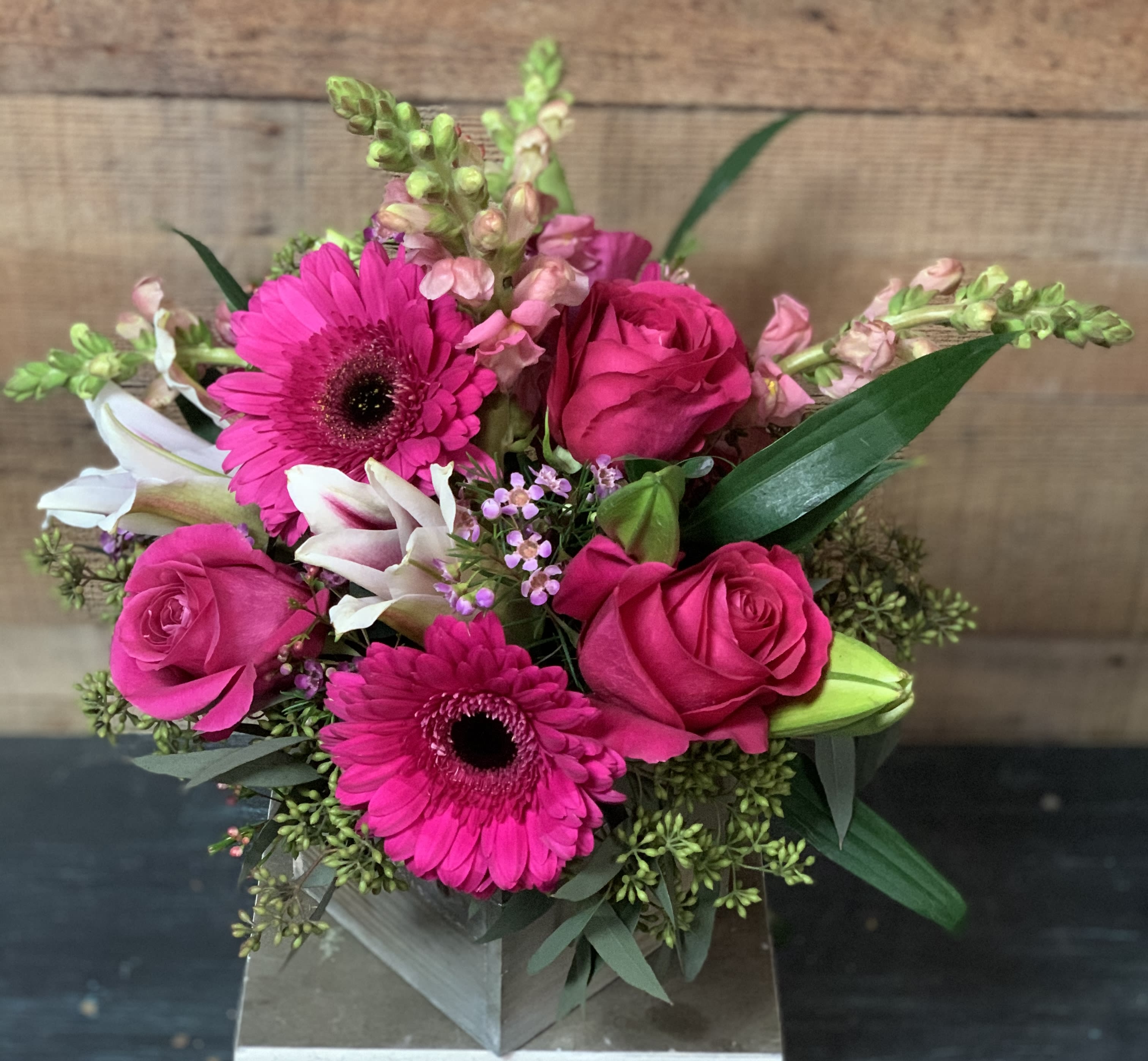 Hot Pink Obsession - Roses, Gerberas, Snapdragons, and Lilies in a rustic wooden cube. Great as a centerpiece at your special event.  If you would like a color change please put it under the special instructions.