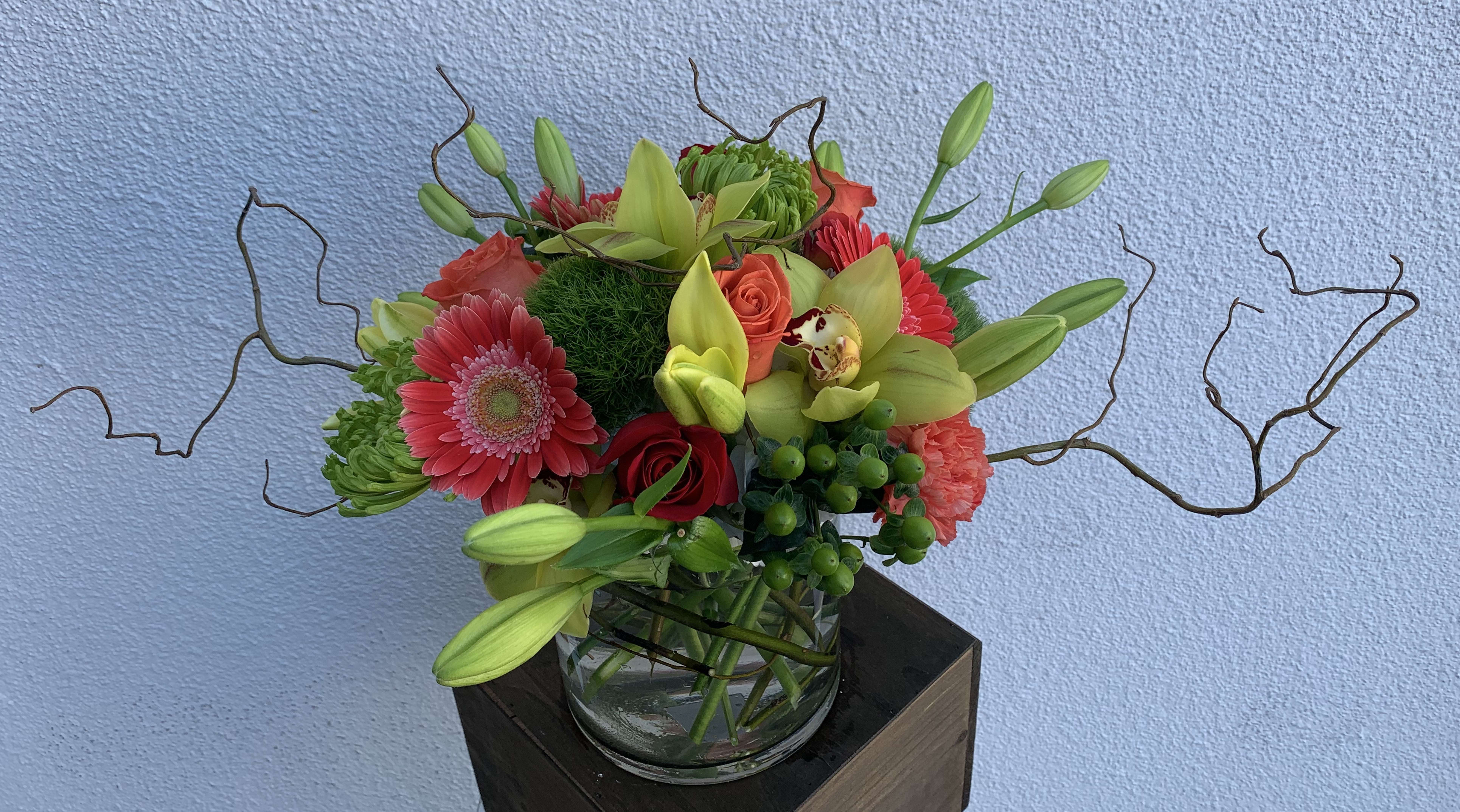 Summer Breeze Summer Breeze - A refreshing arrangement of green cymbidium orchids, green spider mums, orange gerbera daisies, orange and red roses, and yellow lilies.