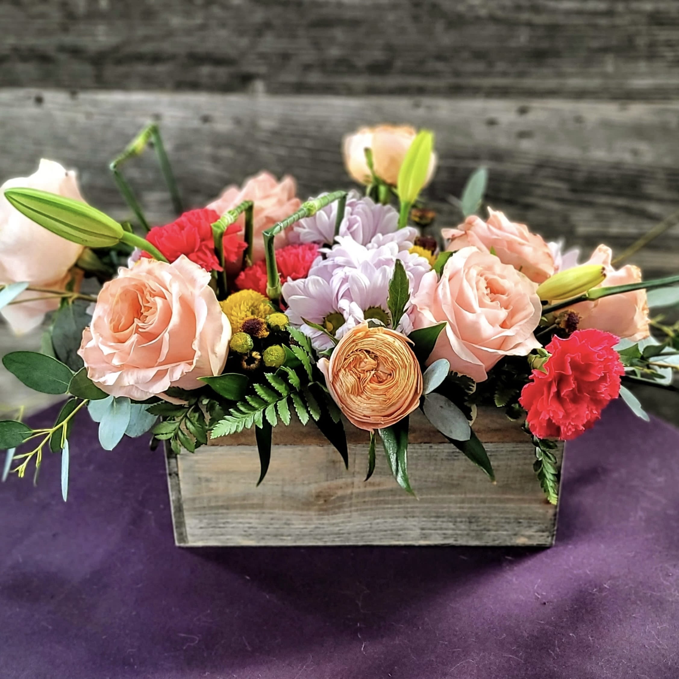 Chic - Well, this is different! It's a unique take on flowers, with little details that you don't see every day. A chic look in a wooden box. Roses, carnations, daisies, and more. Sure to get attention. 