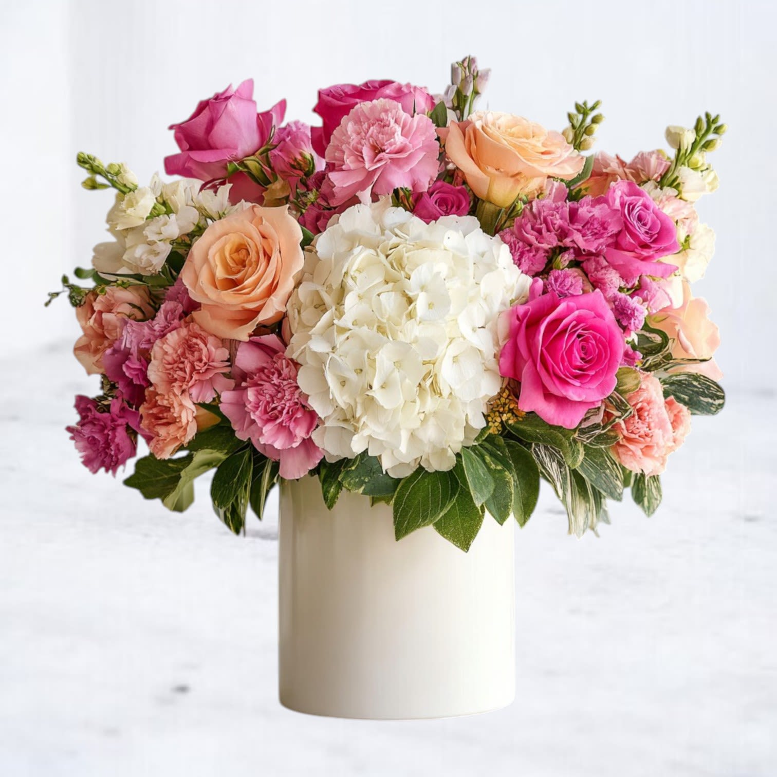 Effloresce Effloresce - Our Effloresce bouquet is a joyful expression of beauty, filled with lush roses, soft carnations, voluminous hydrangea, and accents of delicate seasonal blooms. Designed in a modern white vase, this arrangement blends warm peach, vibrant pink, and crisp white for a look that’s both cheerful and refined. Perfect for birthdays, celebrations, thank-you gifts, or to brighten any home, this bouquet captures attention with its luxurious blooms and radiant color palette. Available for same-day flower delivery across Houston, Magnolia, The Woodlands, Conroe, Cypress, and surrounding areas, it’s the ideal gift to make any moment unforgettable.