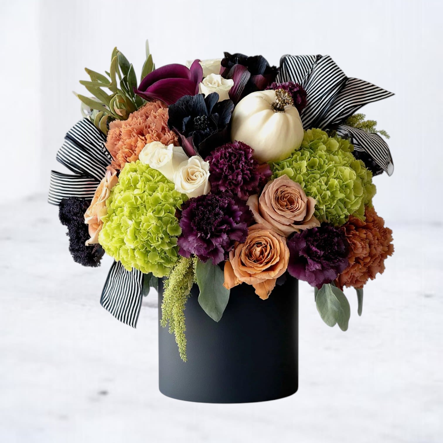 Wickedly Elegant Wickedly Elegant - Bold, dramatic, and unforgettable—our Wickedly Elegant Bouquet is a showstopping arrangement designed to capture attention. Featuring rich purple hydrangea, velvety black calla lilies, vibrant orange roses, and luxe peach blooms, it’s artfully arranged in a sleek black vase with striped ribbon for a modern, editorial finish. Perfect for fall celebrations, Halloween gatherings, or as a chic gift for someone who loves statement florals, this bouquet blends moody sophistication with seasonal charm. Available for same-day flower delivery in Magnolia, The Woodlands, Spring, Conroe, Cypress, and surrounding Houston areas.
