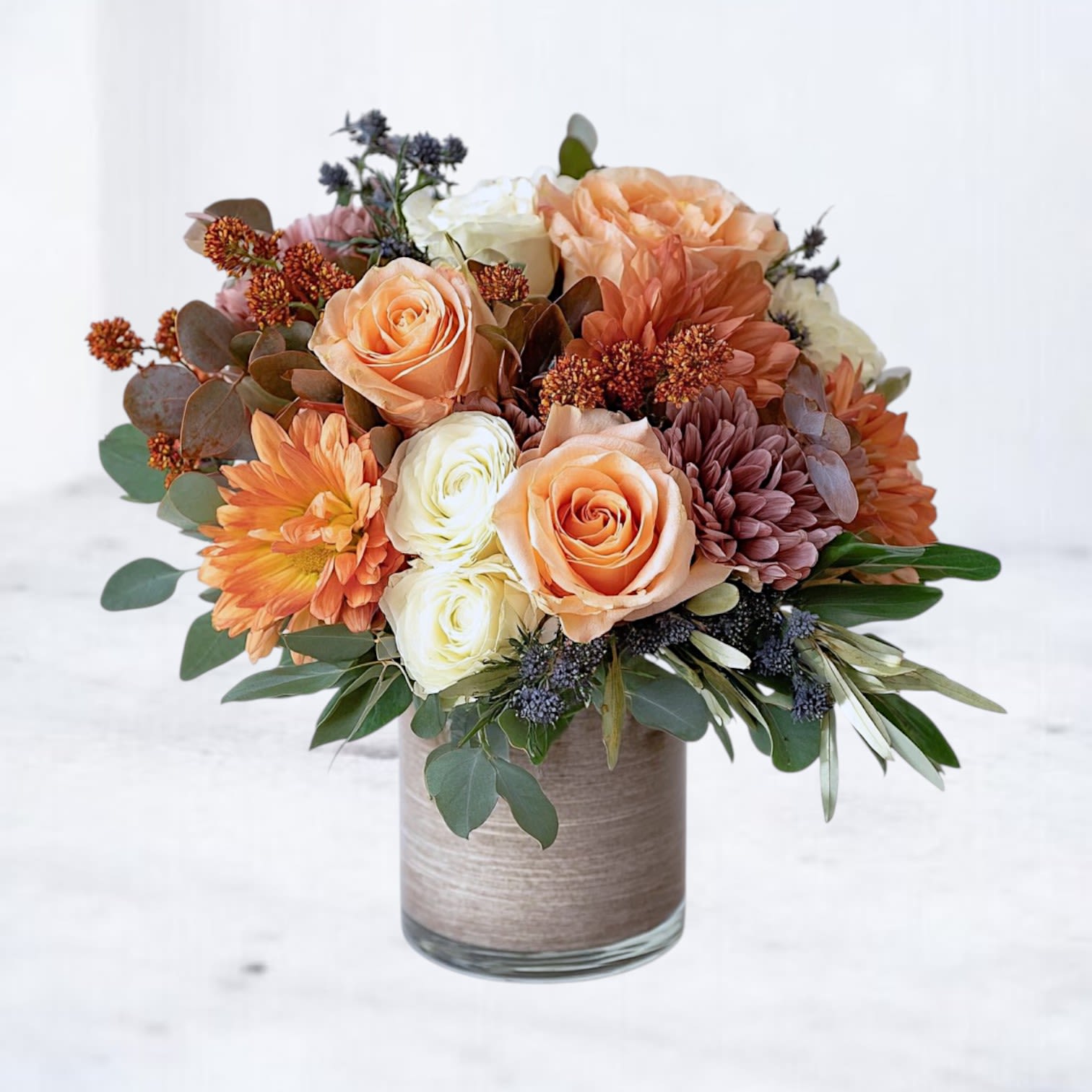 Sunset Ember Sunset Ember - The Sunset Ember Bouquet brings the warmth of autumn indoors with glowing orange roses, creamy ivory blooms, bronze mums, and textured seasonal accents. Designed in a modern vase with lush greenery, this bouquet balances elegance and rustic charm, making it ideal for birthdays, anniversaries, or fall celebrations. Its cozy palette reflects the beauty of the season, offering a heartfelt way to brighten someone’s day. Available for same-day flower delivery in Magnolia, The Woodlands, Spring, Montgomery, Houston, and surrounding areas, the Sunset Ember Bouquet is a timeless gift for any occasion.