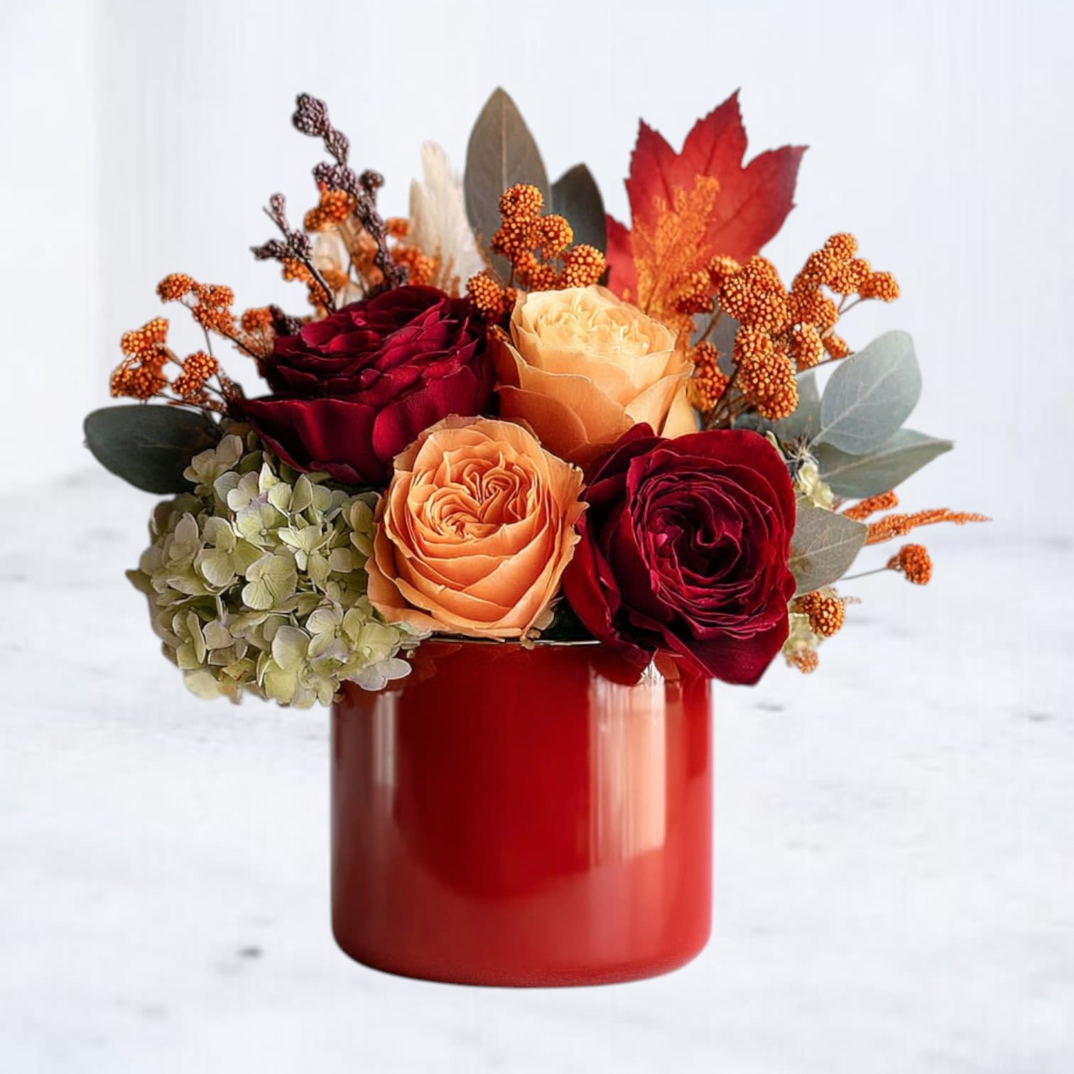 Fireside Light Fireside Light - Bring the glowing warmth of autumn into any space with our Fireside Light bouquet. This rich seasonal arrangement features deep crimson and vibrant orange roses, hydrangea, and fiery bronze accents, all artfully arranged in a sleek 4x4 red vase. The bold hues and lush textures evoke the comfort of sitting beside a crackling fire on a crisp fall evening. Perfect for fall gatherings, holiday décor, or as a heartfelt gift, Fireside Radiance is a stunning reminder of the season’s beauty and warmth.