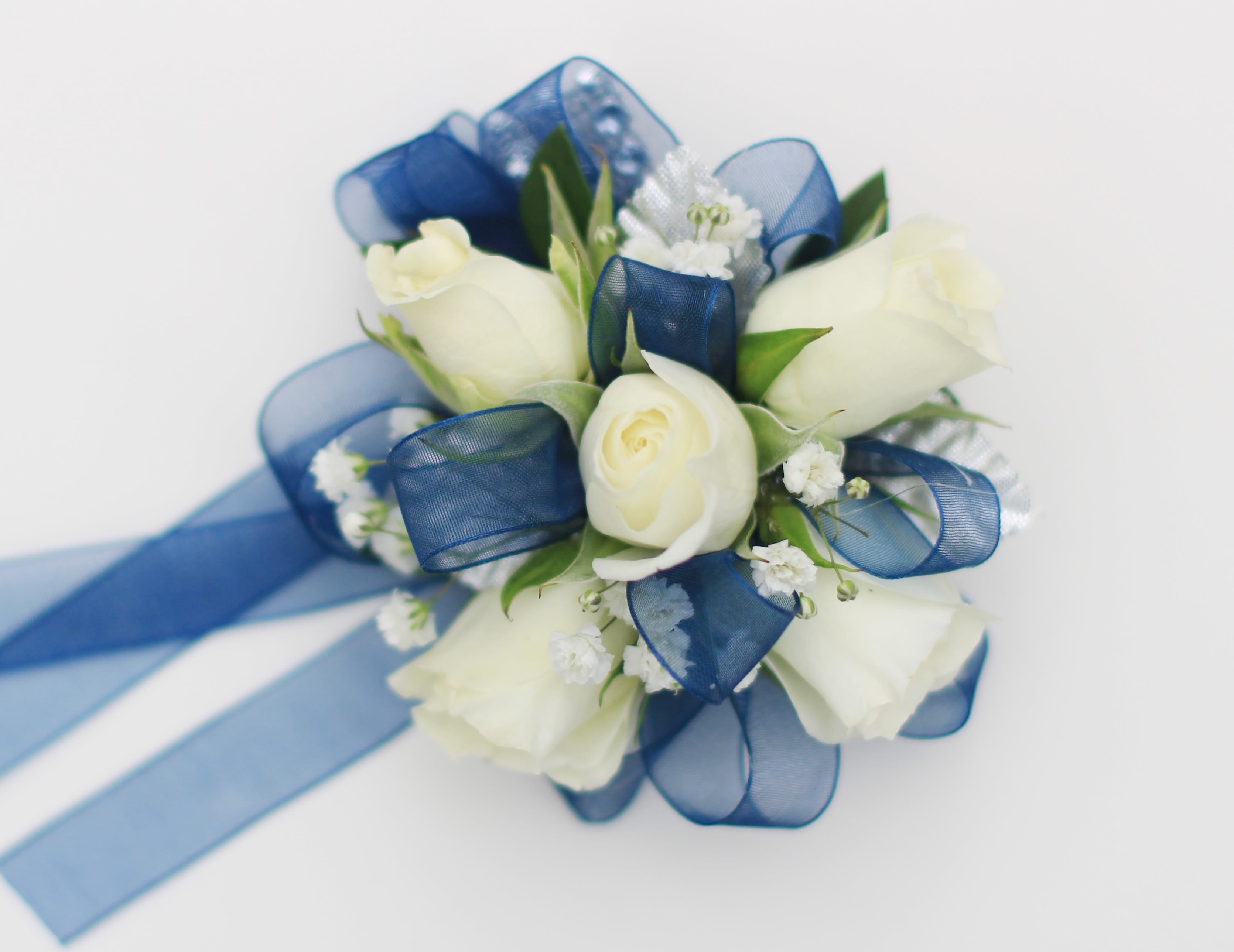 White Rose Corsage with Navy Ribbon - Wrist corsage featuring white spray roses, babies breath, and navy ribbon. Perfect for prom or homecoming!