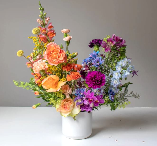 Lilo Lilo - Bright, bold, and bursting with color — this vibrant arrangement captures the energy of summer with fiery oranges, hot pinks, sunny yellows, with a touch of royal blues. A refreshing splash of seasonal joy for any space.