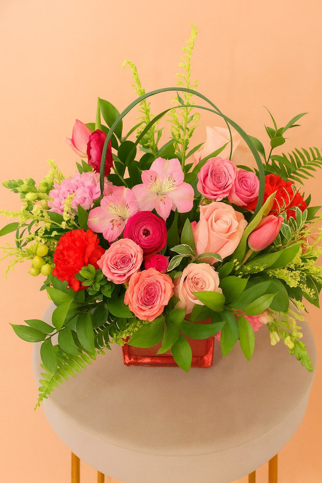 Rosé All Day Rosé All Day - Rosé All Day is a lush, vibrant mix of pink and peach roses, ranunculus, alstroemeria, and snapdragons, elegantly accented with lily grass and lush greenery. Designed in a chic rose gold cube vase, this arrangement radiates charm and sophistication- perfect for celebrating life's sweetest moments.