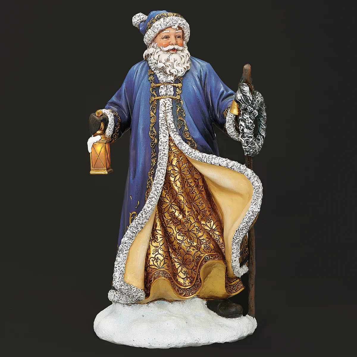 CHRISTMAS - Lighted Blue and Gold Santa with Wreath and Lantern - From the Joseph's Studio Collection, this beautifully crafted Blue Santa holds a holiday wreath and glowing lantern. Accented with soft LED lighting and detailed in serene blue tones, it brings a peaceful glow to mantels, tabletops, or entryways throughout the Christmas season.  Material: Resin/Stone Mix  Size: 15.5&quot; H   Power: LED, Battery Operated