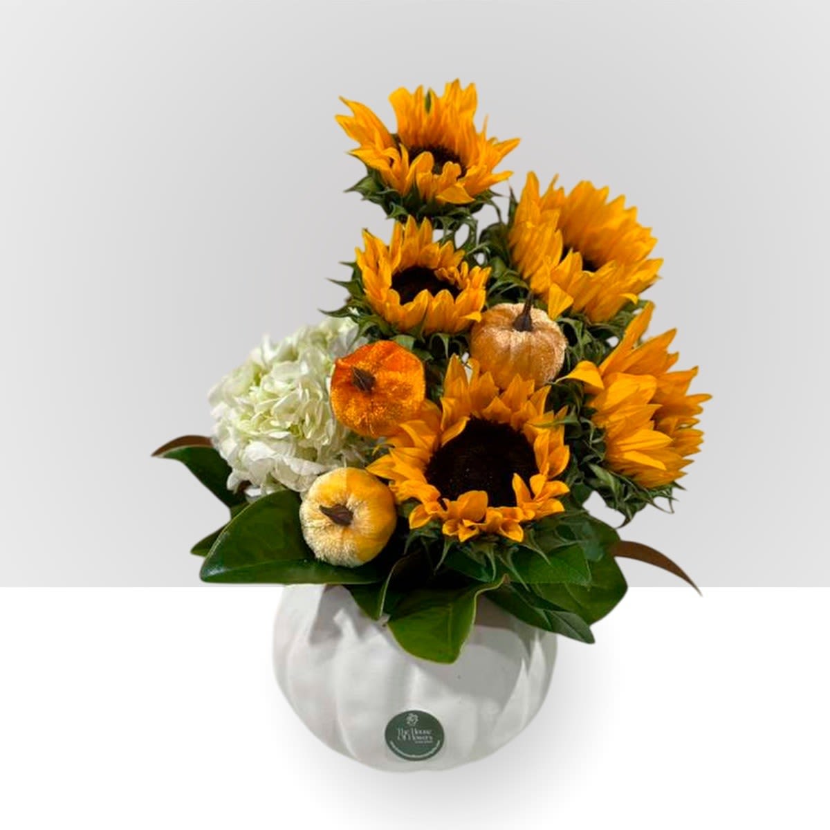 Autumn flowers by The House of Flowers Autumn flowers by The House of Flowers - Brighten up your fall with dazzling sunflowers accompanied by white hydrangeas and a special touch of artificial pumpkins. The arrangement is presented on a ceramic pumpkin base.