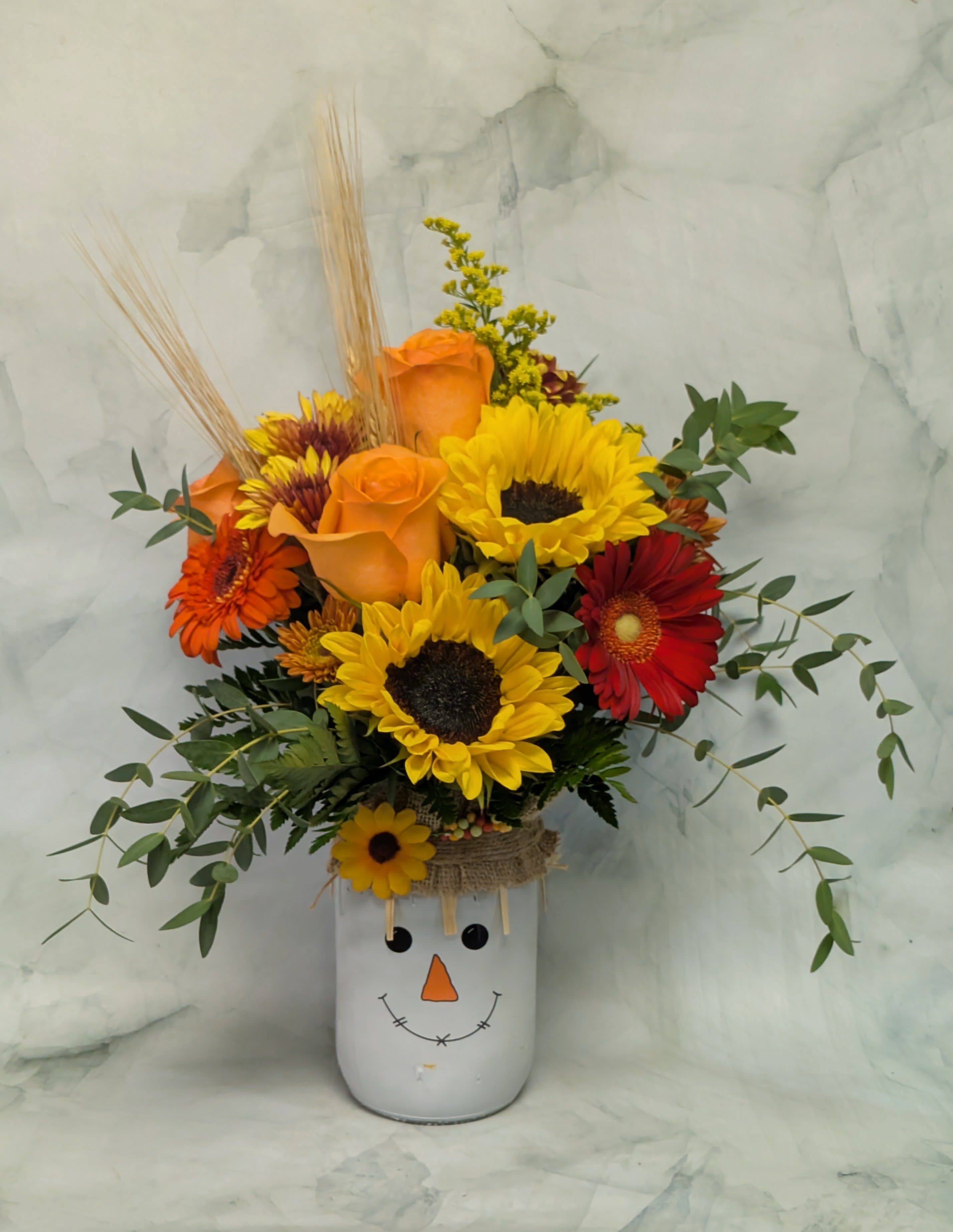 Smiling Scarecrow Smiling Scarecrow - This scarecrow may not be doing it's job scaring crows away, but it sure is putting a smile on everyone's face. Spread some Fall cheer this year with our new scarecrow mason jar. The arrangement includes sunflowers, roses