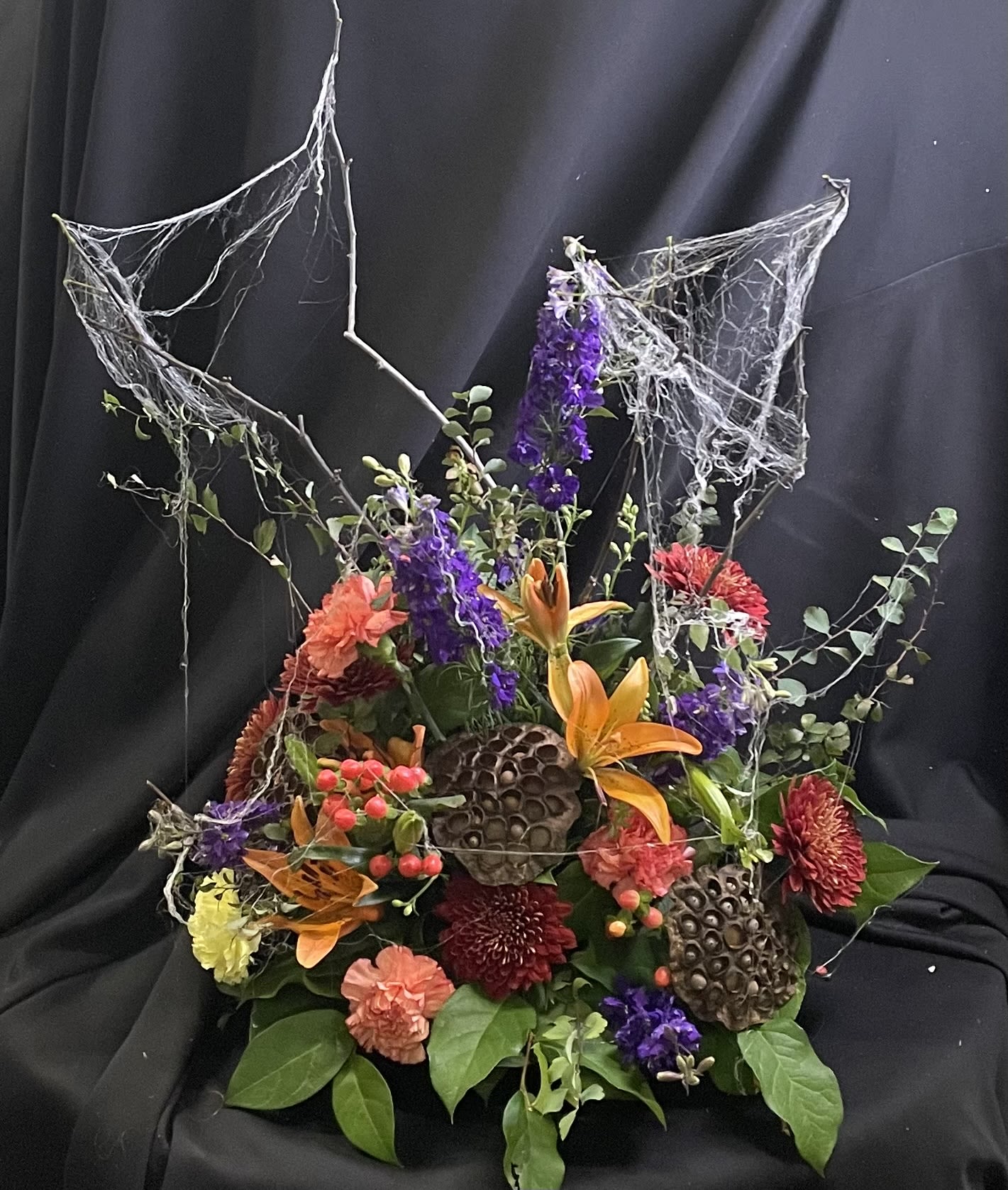 Flowers and Spooks  - Cobwebs, anyone??  A playful take on fresh flowers for Halloween- guaranteed to bring a smile on this scariest of holidays!  Flowers and size will vary, but the look will be so much fun!