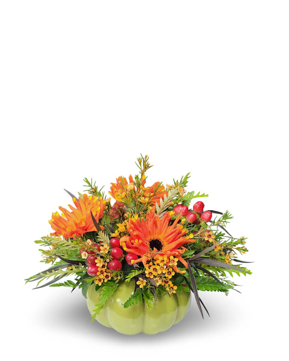 Poppin' Pumpkin Poppin' Pumpkin - Brighten your space with Poppin’ Pumpkin, a fun and festive fall arrangement bursting with color and charm. Vibrant orange blooms, cheerful yellow accents, and playful pops of red berries come together in a cute green pumpkin container. This joyful piece captures the spirit of the season and adds a perfect touch of autumn warmth to any table or desk. Approximately 9 inches wide by 7 inches tall.