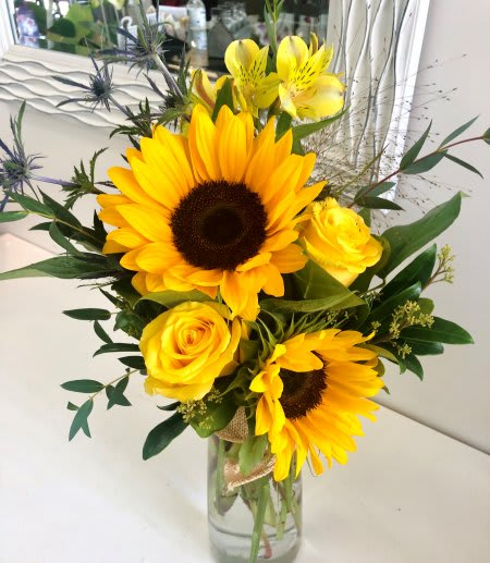 Sunny Day Sunny Day - Vibrant sunflowers and yellow roses arranged with greenery into a tall vase.