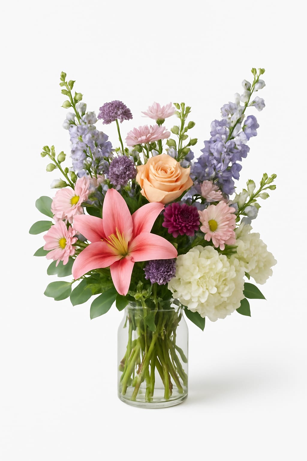 Elegant Garden Vase Arrangement Elegant Garden Vase Arrangement - Bring the beauty of a blooming garden indoors with this lush and luxurious arrangement. A stunning blend of peach roses, lilies, delicate lavender stock, white hydrangea, and soft pink daisies come together in a clear glass vase to create an effortlessly elegant display. We try to get it as close as possible but color and flowers may be subtituded due to availablity.