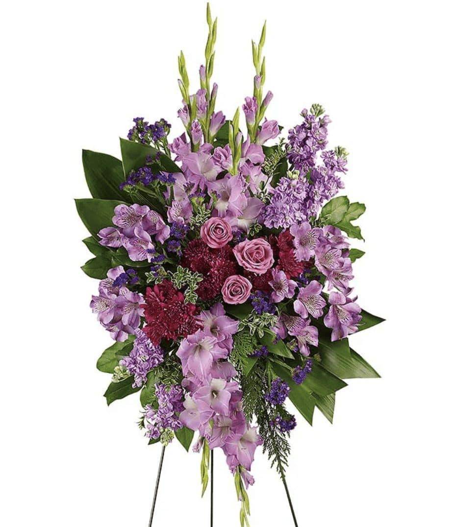 Lavender Reflections Spray - Introducing the Lavender Reflections Spray by DGM Flowers | Fort Lauderdale Florist. This elegant lavender funeral spray is crafted with care and attention to detail. Take a walk through the garden of memories with this lush spray of lavender and purple blooms, accented with fresh green ti leaves. It's a joyful expression of sympathy sure to be appreciated.  Includes:&nbsp; • Purple Spray Roses&nbsp; • Purple Alstroemeria&nbsp; • Purple Gladiolus&nbsp; • Purple Cushion Mums&nbsp; • Sinuata Statice