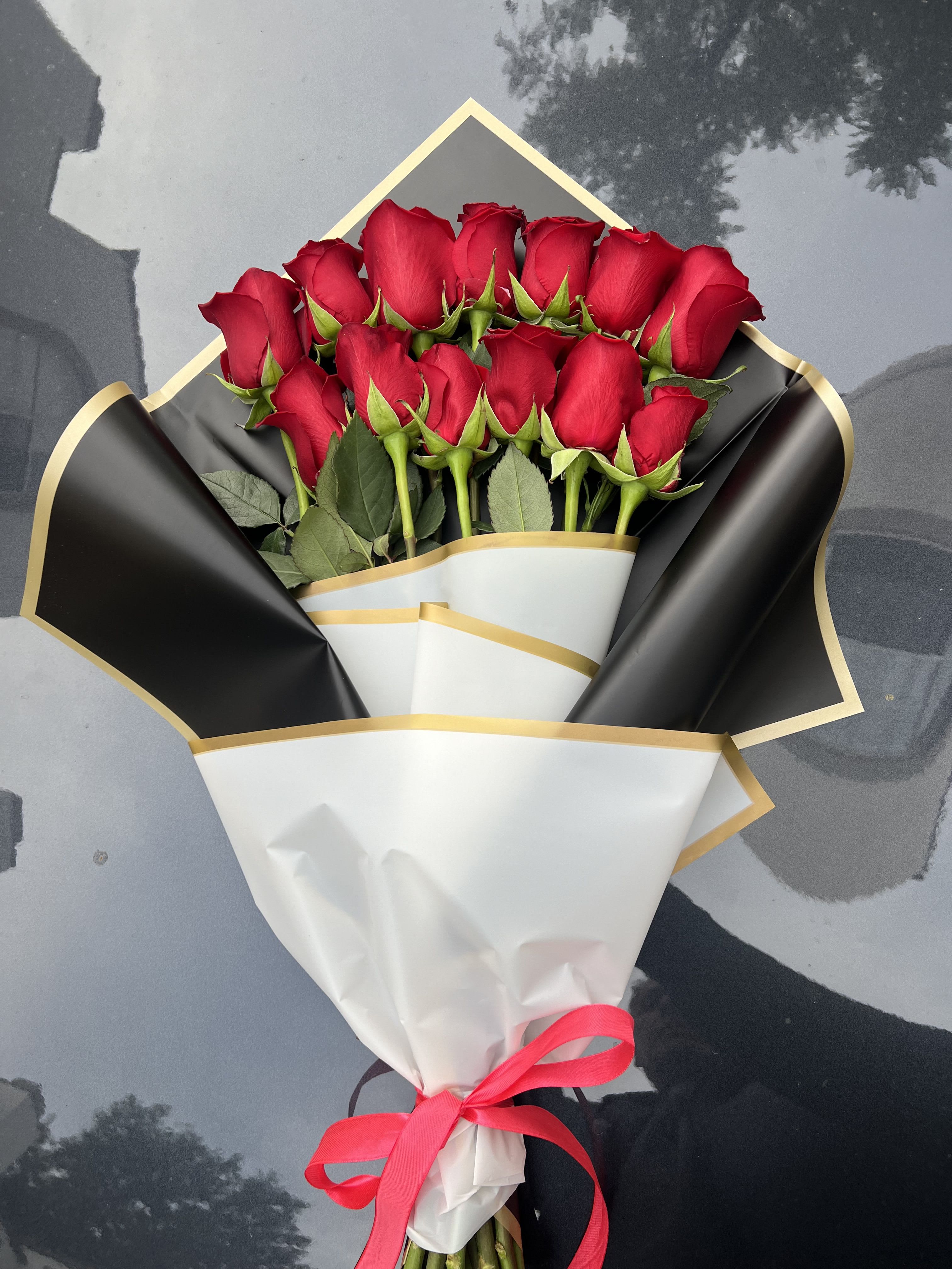 2 lines Roses  - Timeless Elegance: The Perfect Bouquet of Red Roses  Celebrate love and passion with this classic bouquet of vibrant red roses, beautifully wrapped in luxurious black and white with gold accents. Finished with a delicate pink ribbon, this arrangement is the epitome of sophistication and charm.   Features: 	•	Premium, fresh red roses that exude romance. 	•	Stylish and elegant wrapping for a modern touch. 	•	Perfect for anniversaries, birthdays, or romantic surprises.  Give the gift of timeless beauty and heartfelt emotions with this exquisite bouquet.   Order now to make any moment unforgettable!