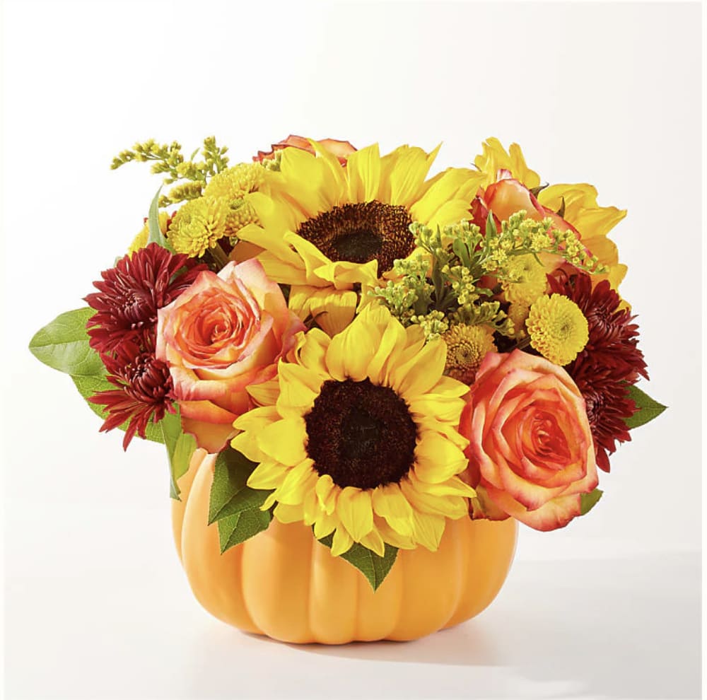 Peter Peter Peter Peter - Ceramic Pumpkin with roses, sunflowers and solidago. Flowers may vary due to seasonality and availability. but the overall theme and look will be similar to photo