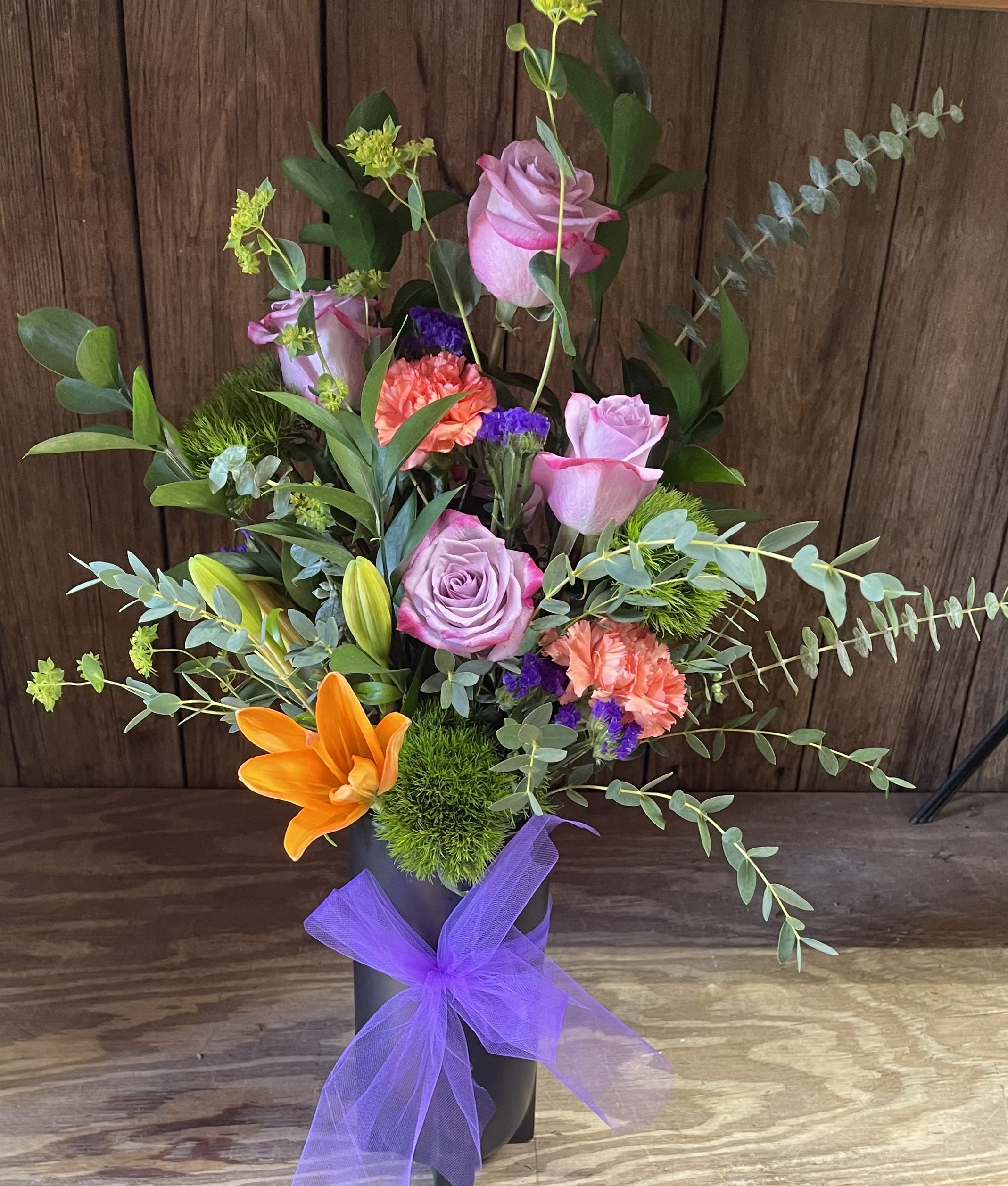 Pretty in Purple Pretty in Purple - Purples and oranges arranged tall in a tall black matte vase.