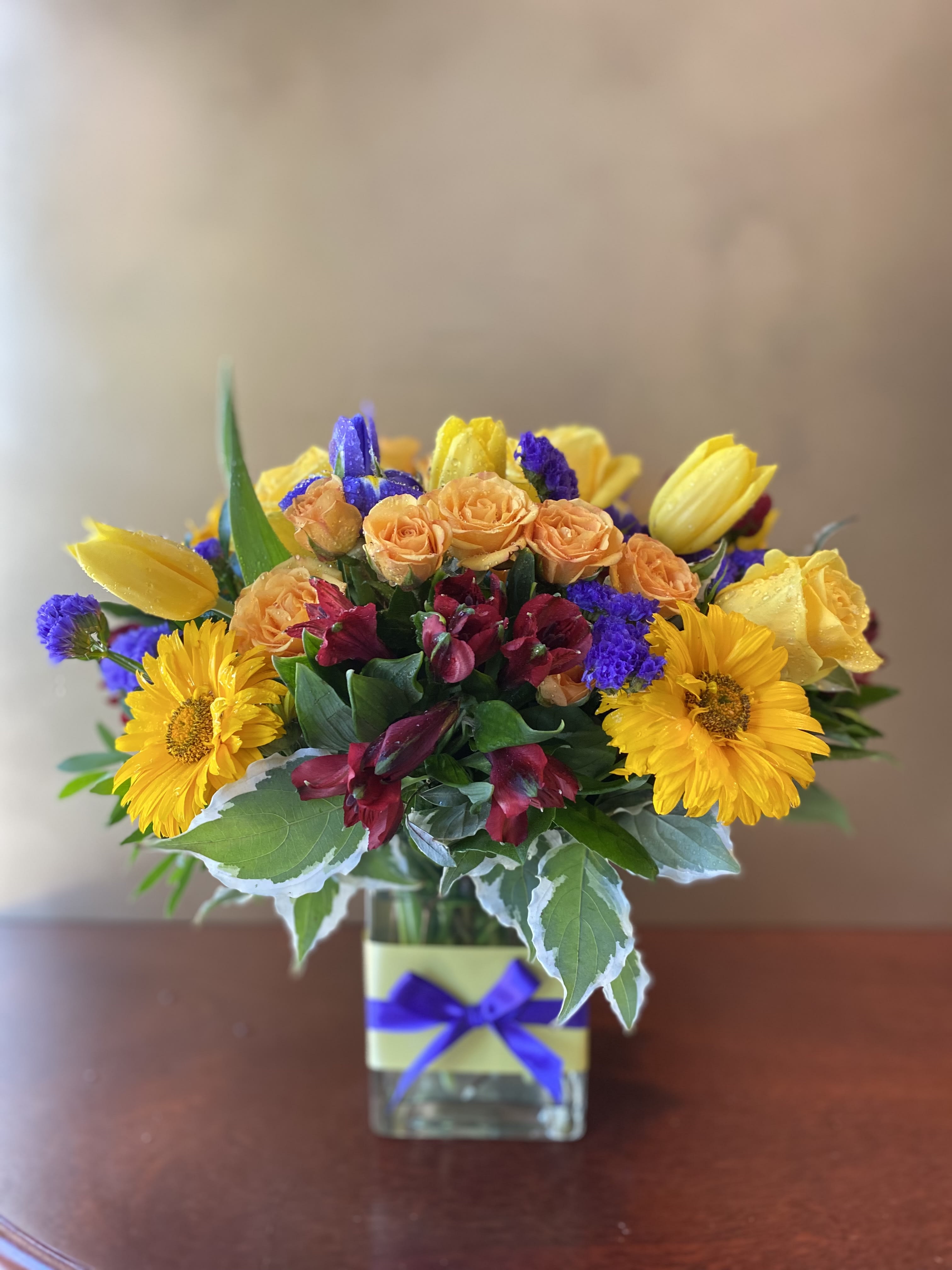 SIGNS OF SPRING  SIGNS OF SPRING  - Send the Floral Garden to give someone the gift of a seasonally appropriate, overflowing garden, right in their home. This bouquet is filled with bright yellow roses, yellow dasies, yellow tulips and more! You can send these as a thank you, a congratulations, or simple a "I'm thinking of you!" Delivered in a clear glass vase, this bouquet is arranged by a local florist and hand-delivered.