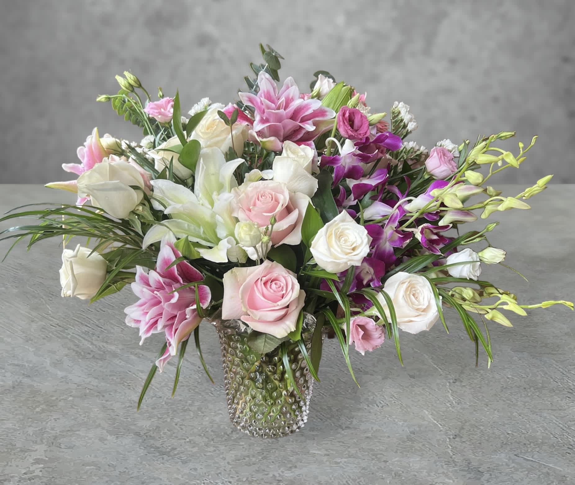 Breezy Pink - Surprise someone special with this playful pop of pink roses, dendrobium orchids and lilies tastefully arranged in a clear glass vase.   