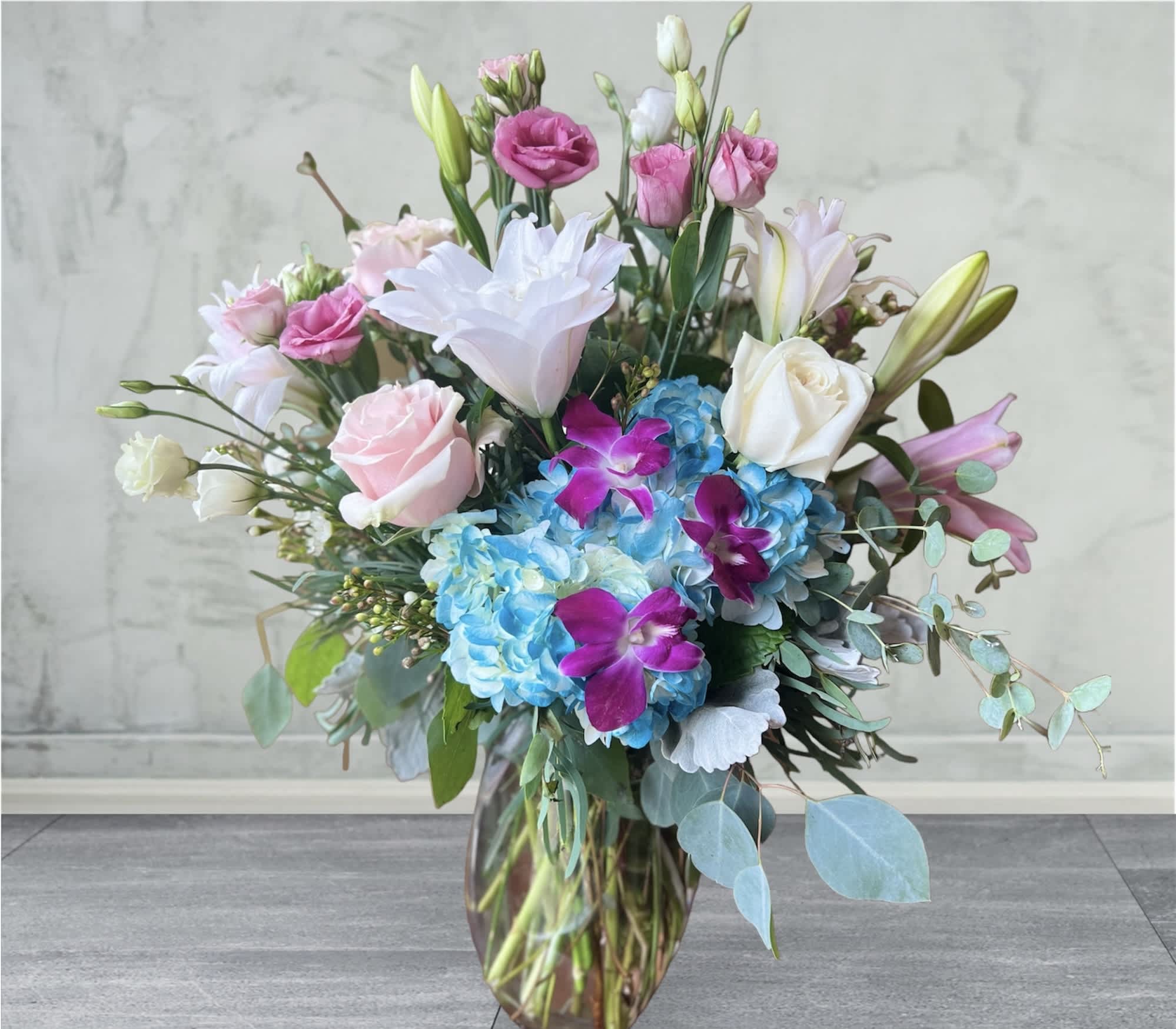 Love Everlasting Love Everlasting - Celebrate the beauty of a life fully lived with this lovely array of lilies, blue hydrangea and other floral favorites.