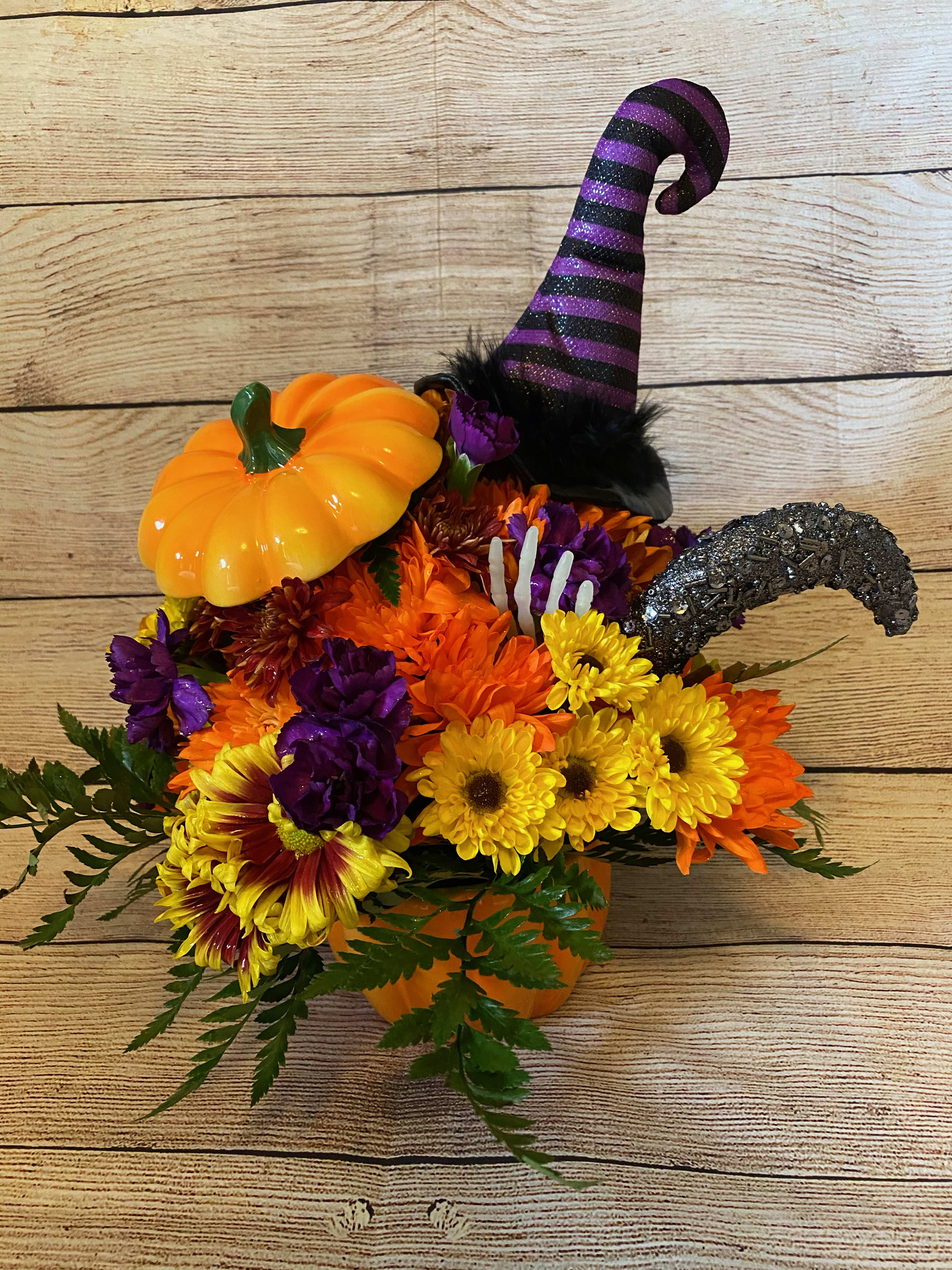 Halloween Fun - Halloween flowers/fall looking flowers inside a pumpkin dish or Halloween mug. Our design may vary from the pictures provided. May contain a witches hat, gnome, pumpkin, or other fun fall insert
